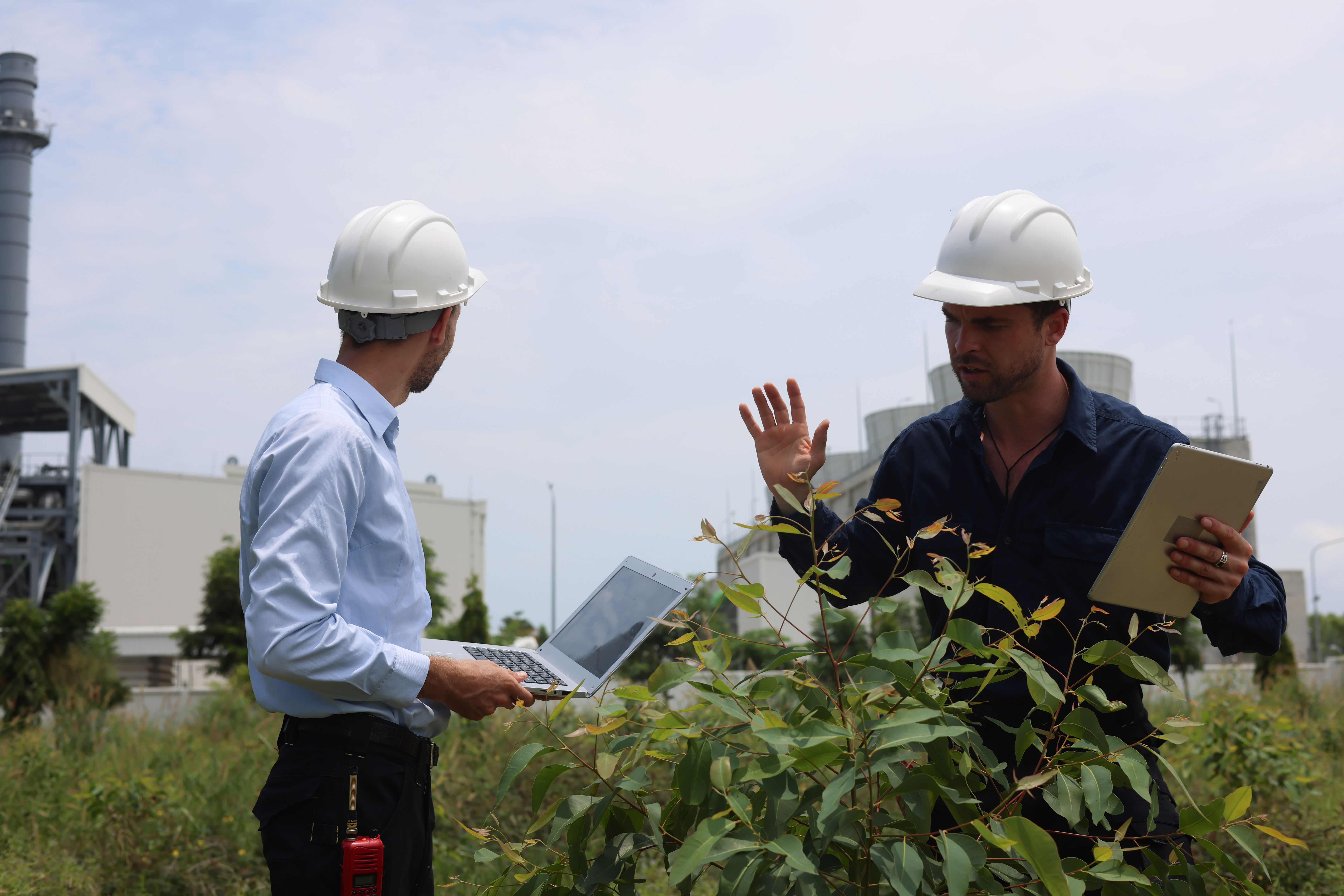 Two male engineers are discussing an ESG environment project, zero carbon at a thermal power plant