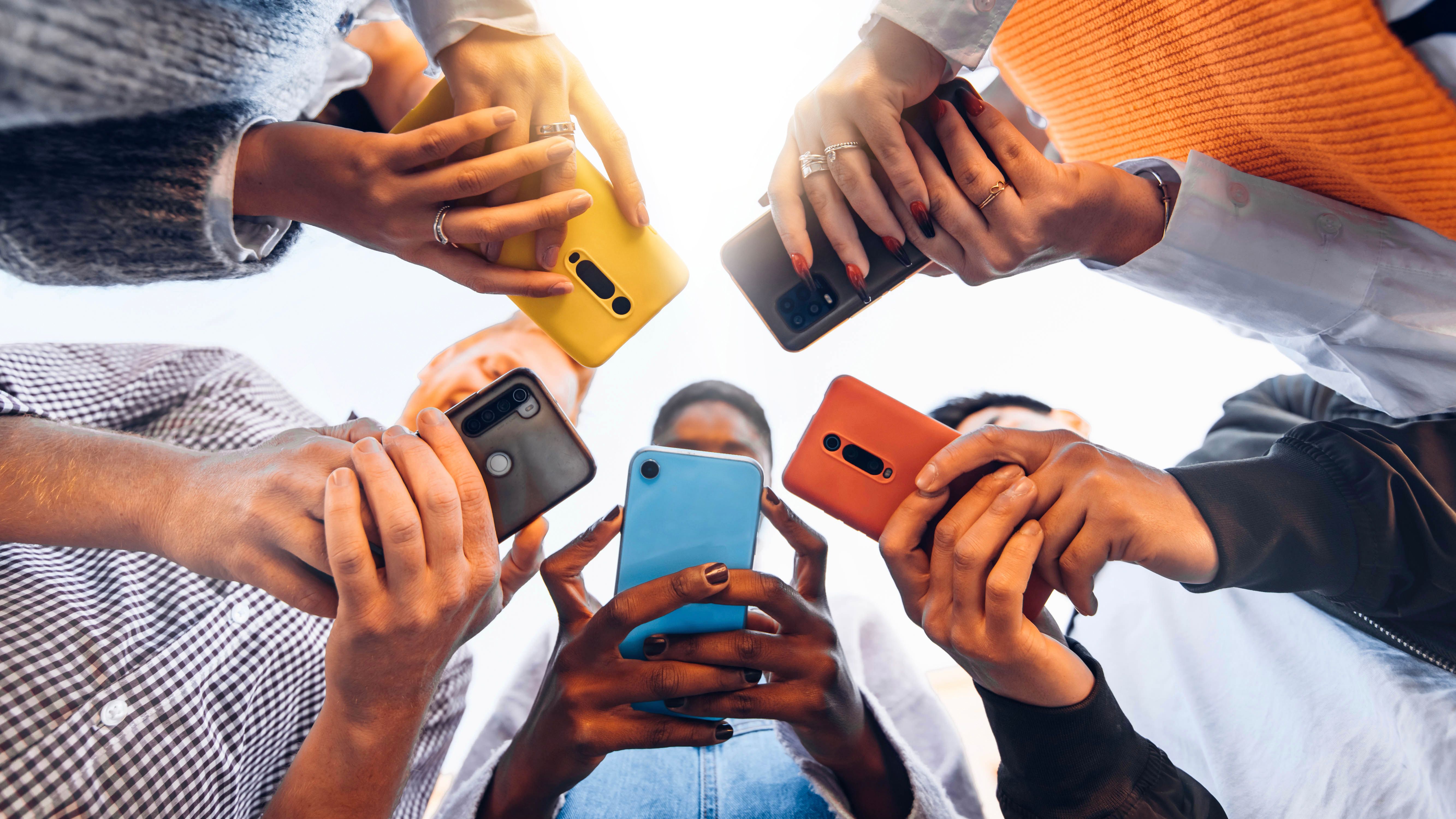 Adolescents en cercle tenant des téléphones intelligents mobiles - Jeunes multiculturels utilisant des téléphones portables à l’extérieur - Adolescents accros au concept de nouvelle technologie