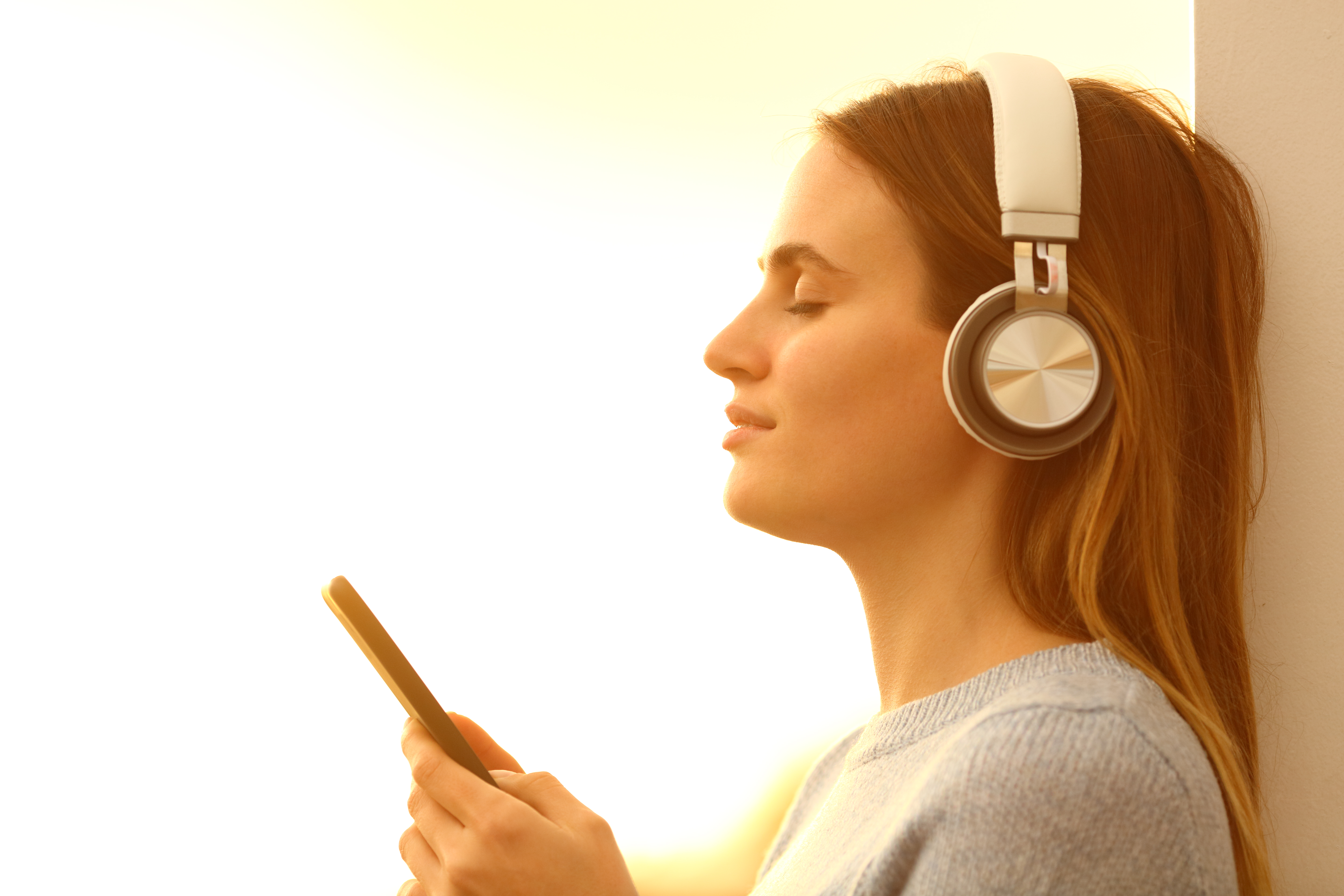 Girl listening to music with headphones and phone