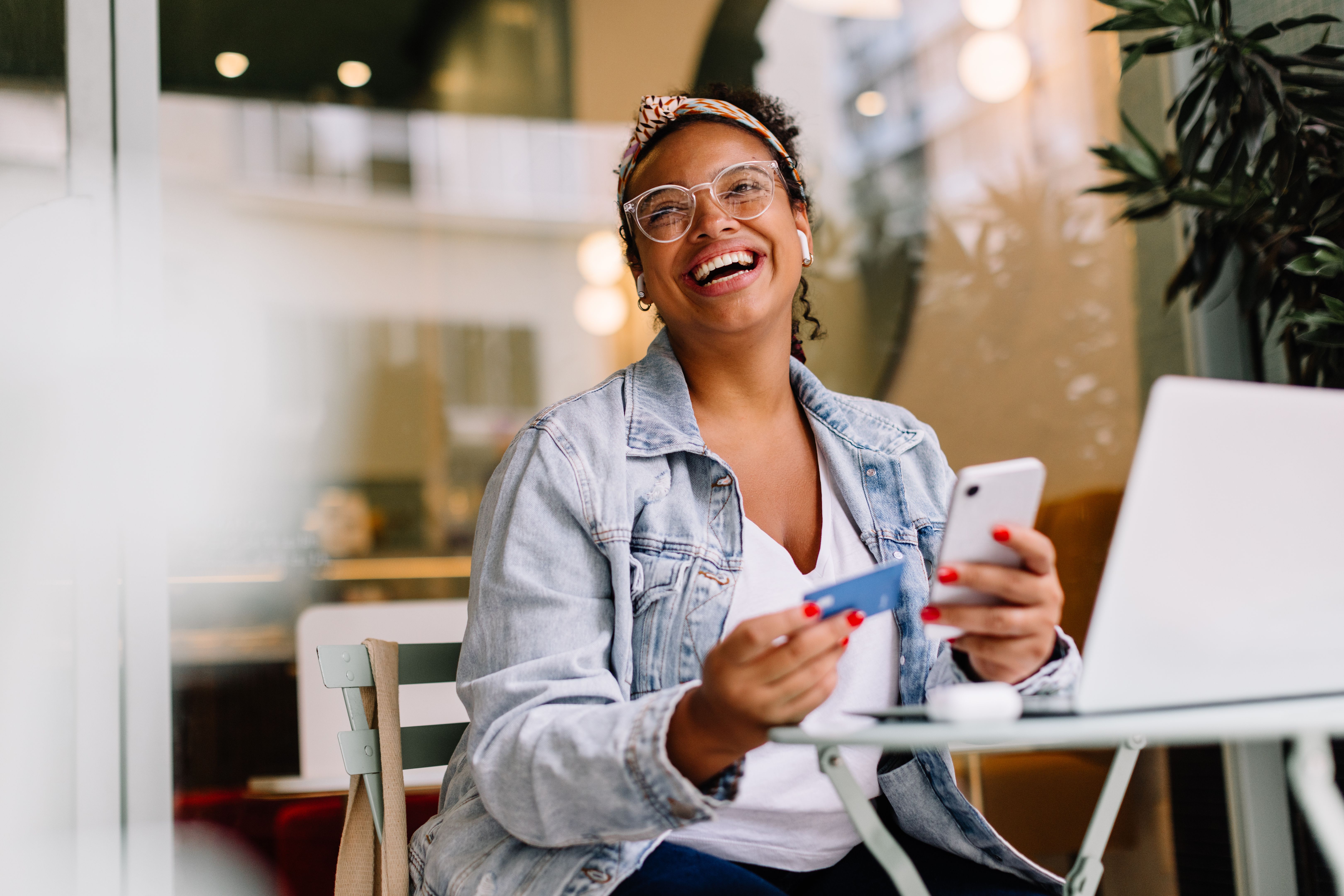 Young woman using smartphone for online shopping in a coffee shop Young woman using smartphone for online shopping in a coffee shop