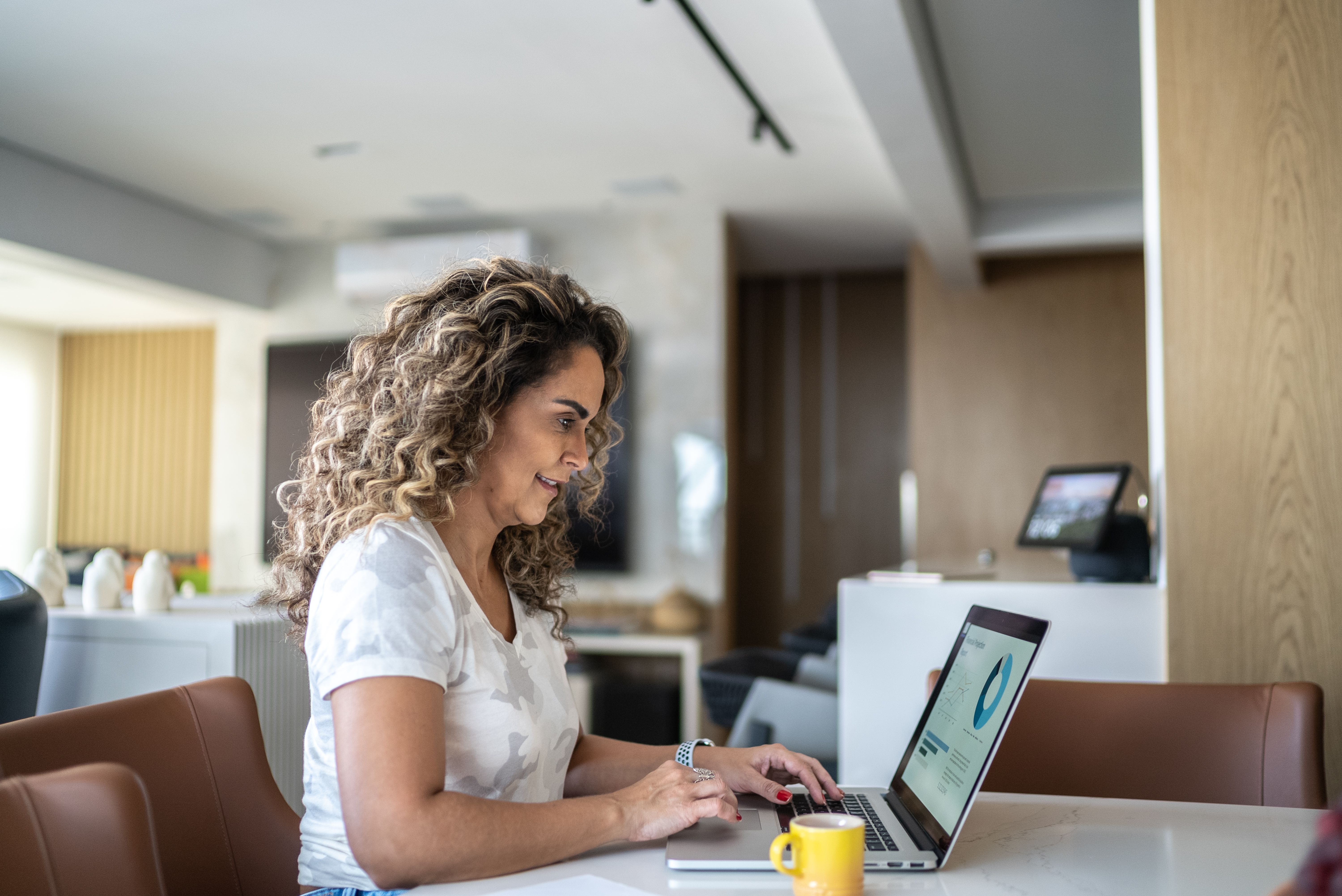 Mature woman using laptop working at home