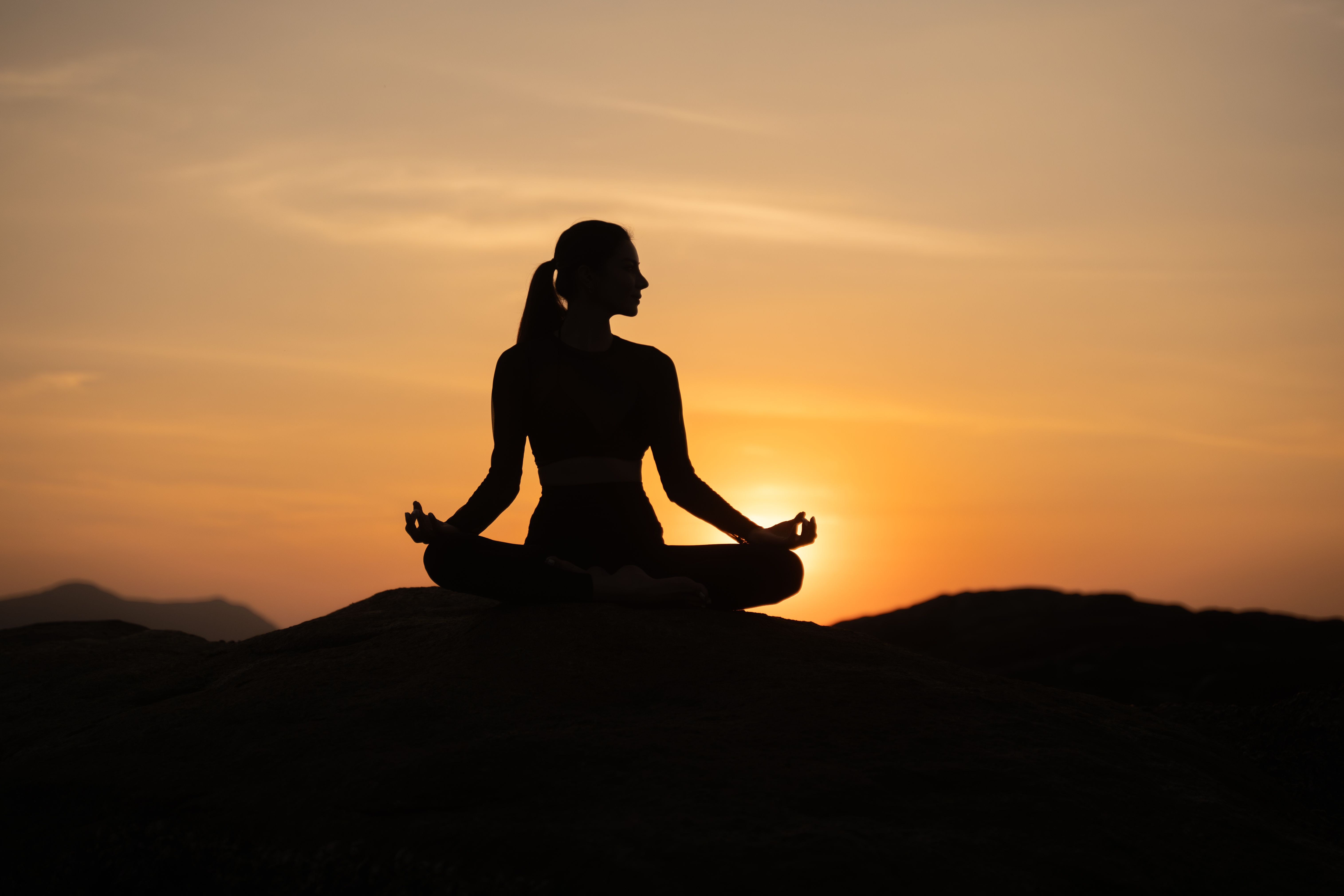 Silhouette of  sport woman striking a graceful yoga pose against the glowing. This image perfectly represents the essence of meditation, wellness, and the pursuit of balance in life.