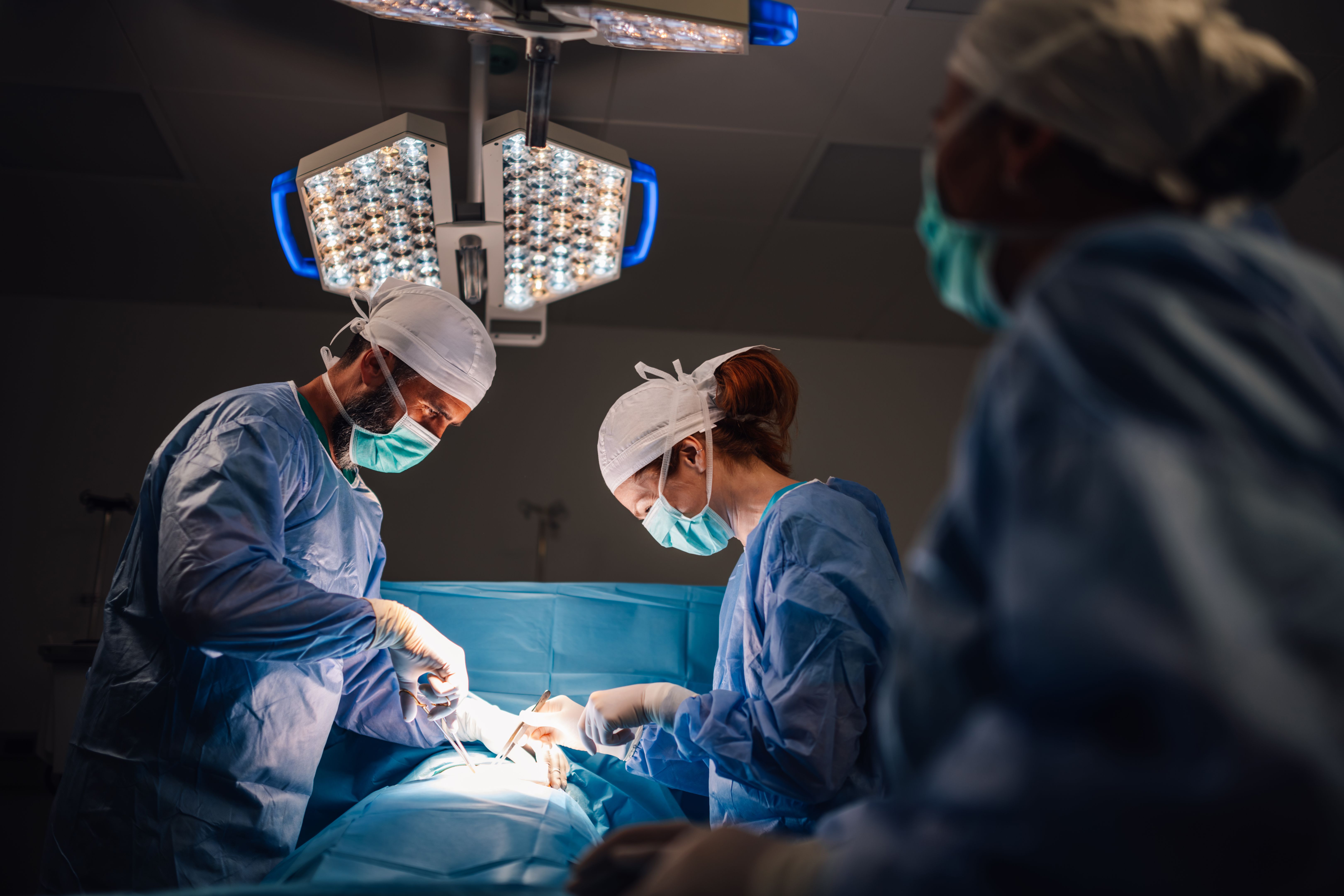 Surgeon team working meticulously on patient in a modern operating theater.