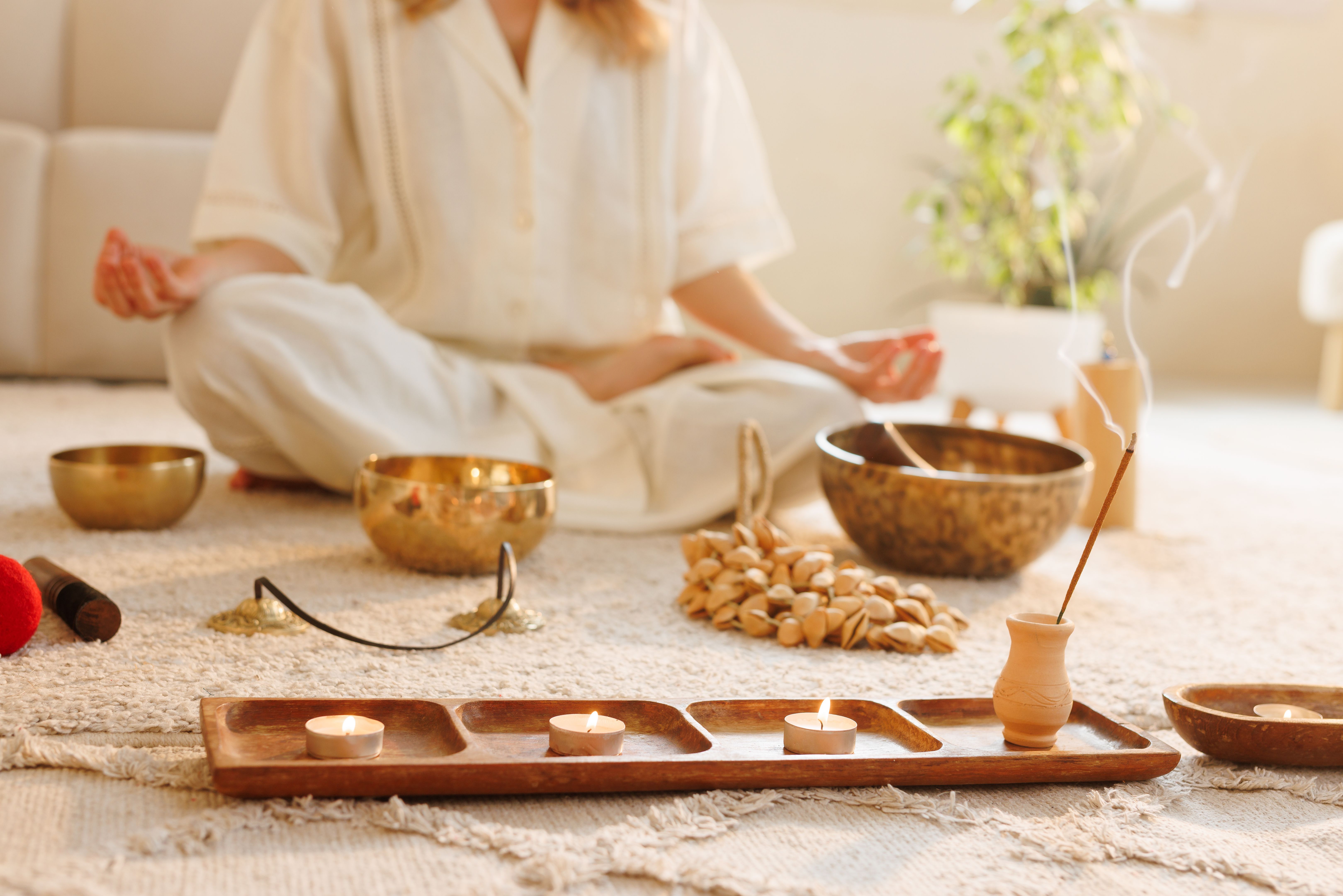 Meditation scene with incense, candles, and singing bowls in a calming home environment.