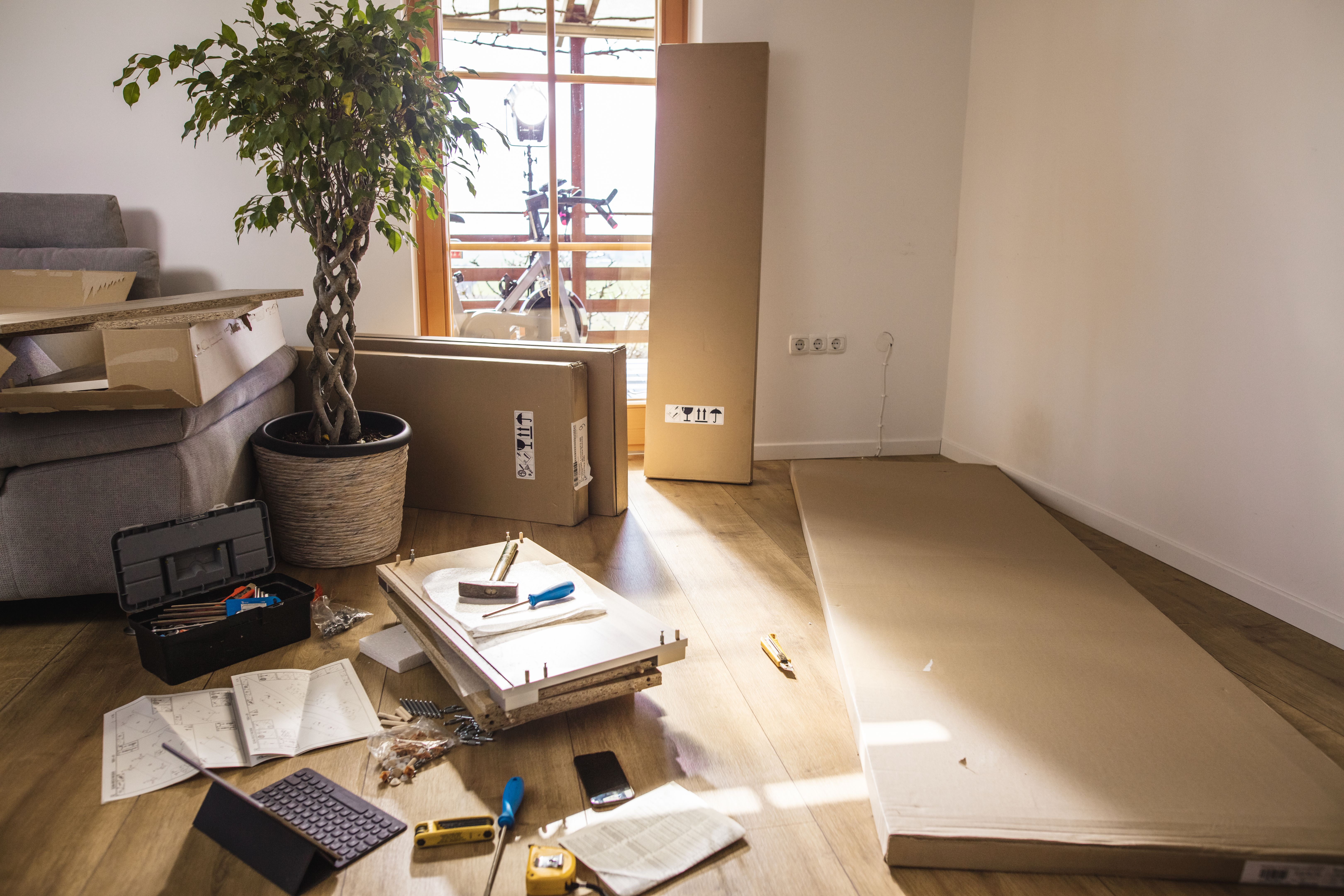 Flat-pack furniture and tools on floor at home