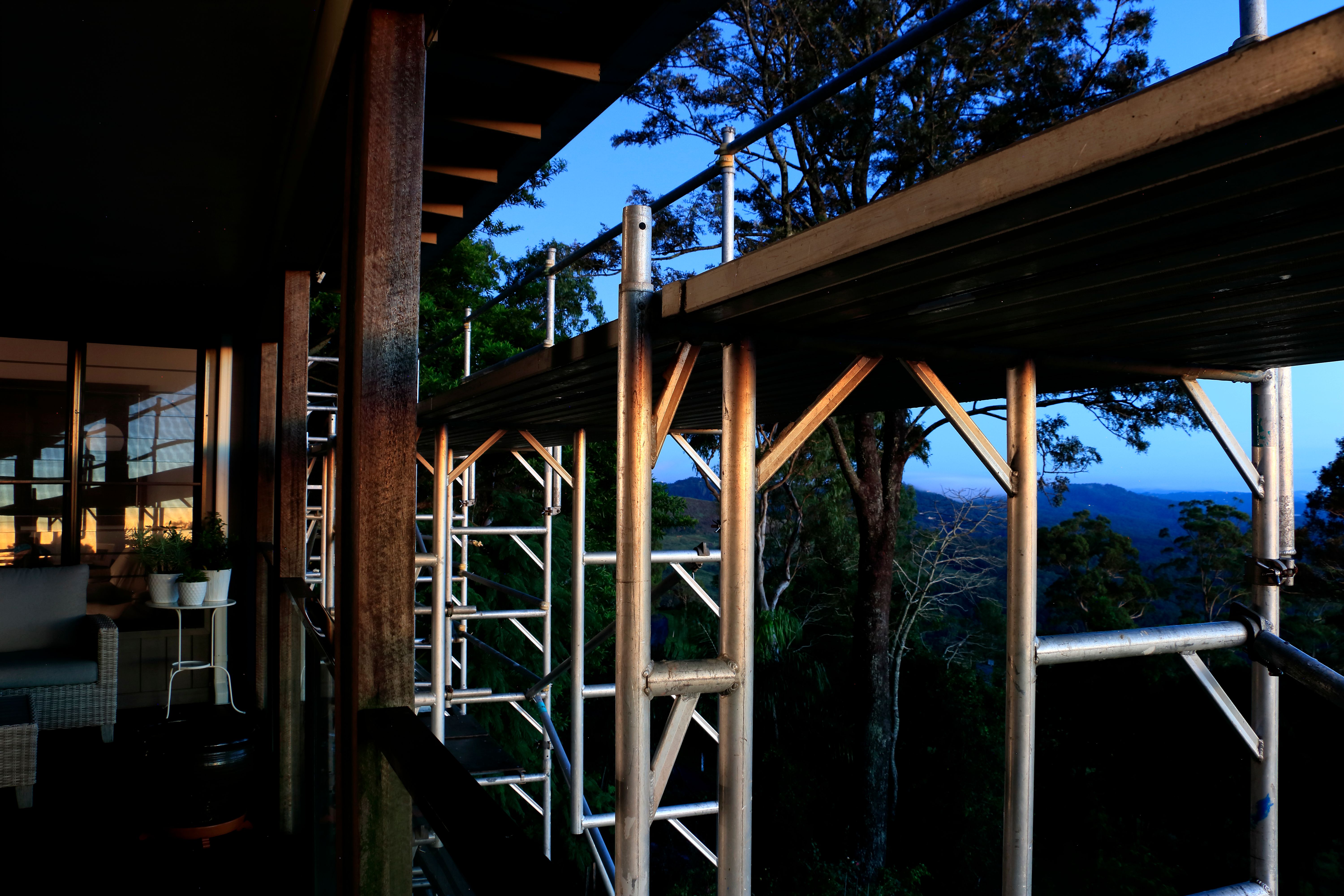 Scaffolding Used for Building Maintenance with Reflected Colors of Sunrise