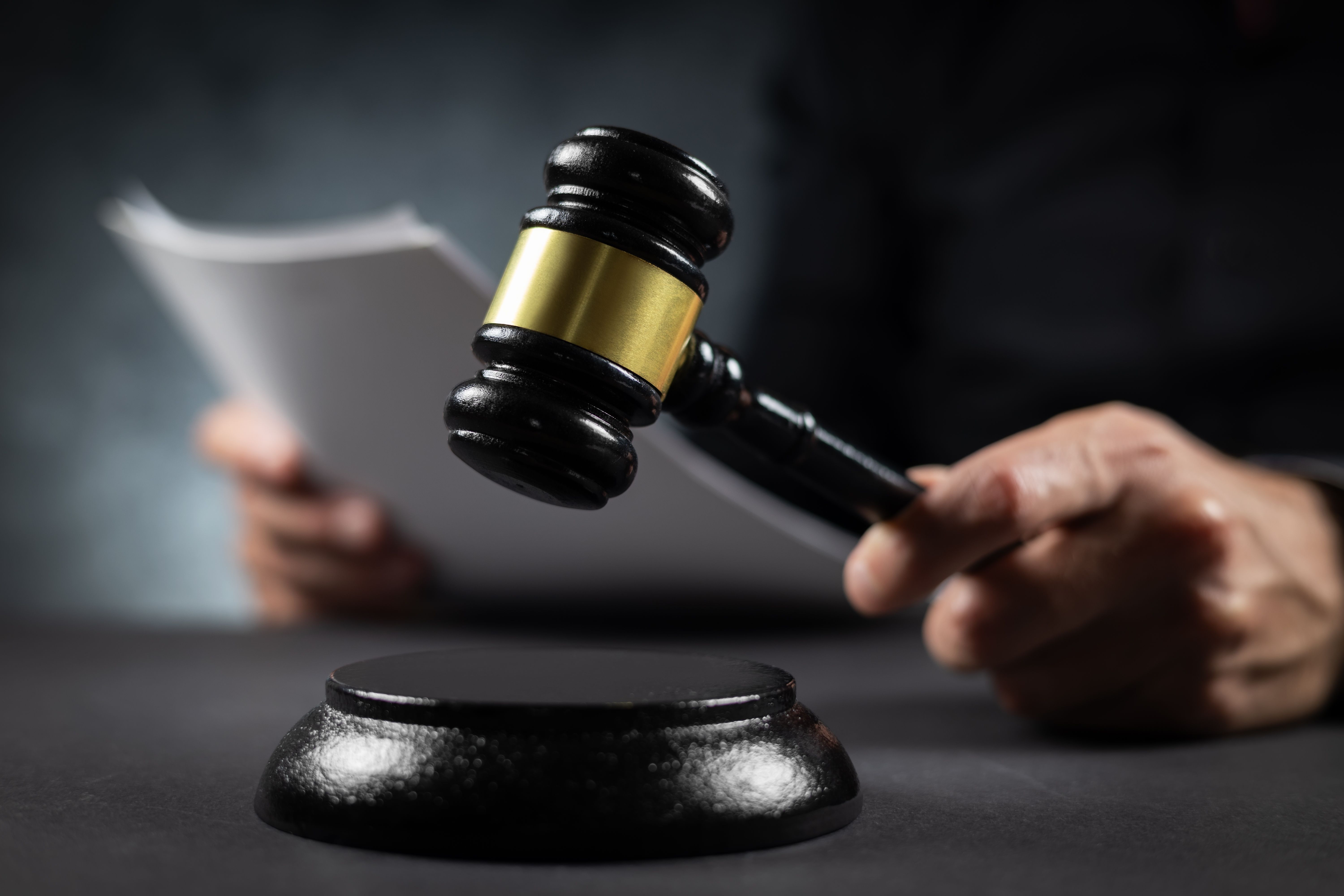 Judge with paper document pronouncing sentence in a court of law.