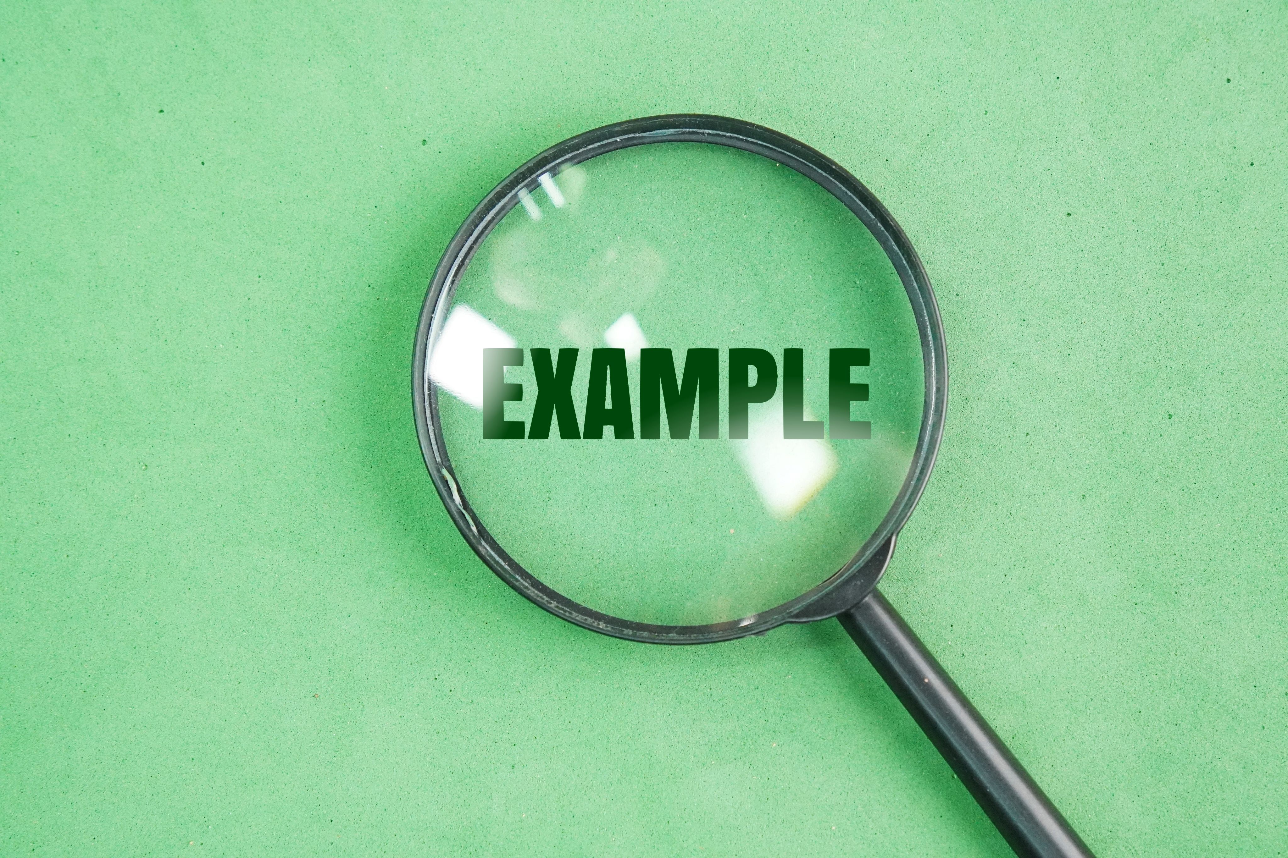 magnifying glass with example words and green background.