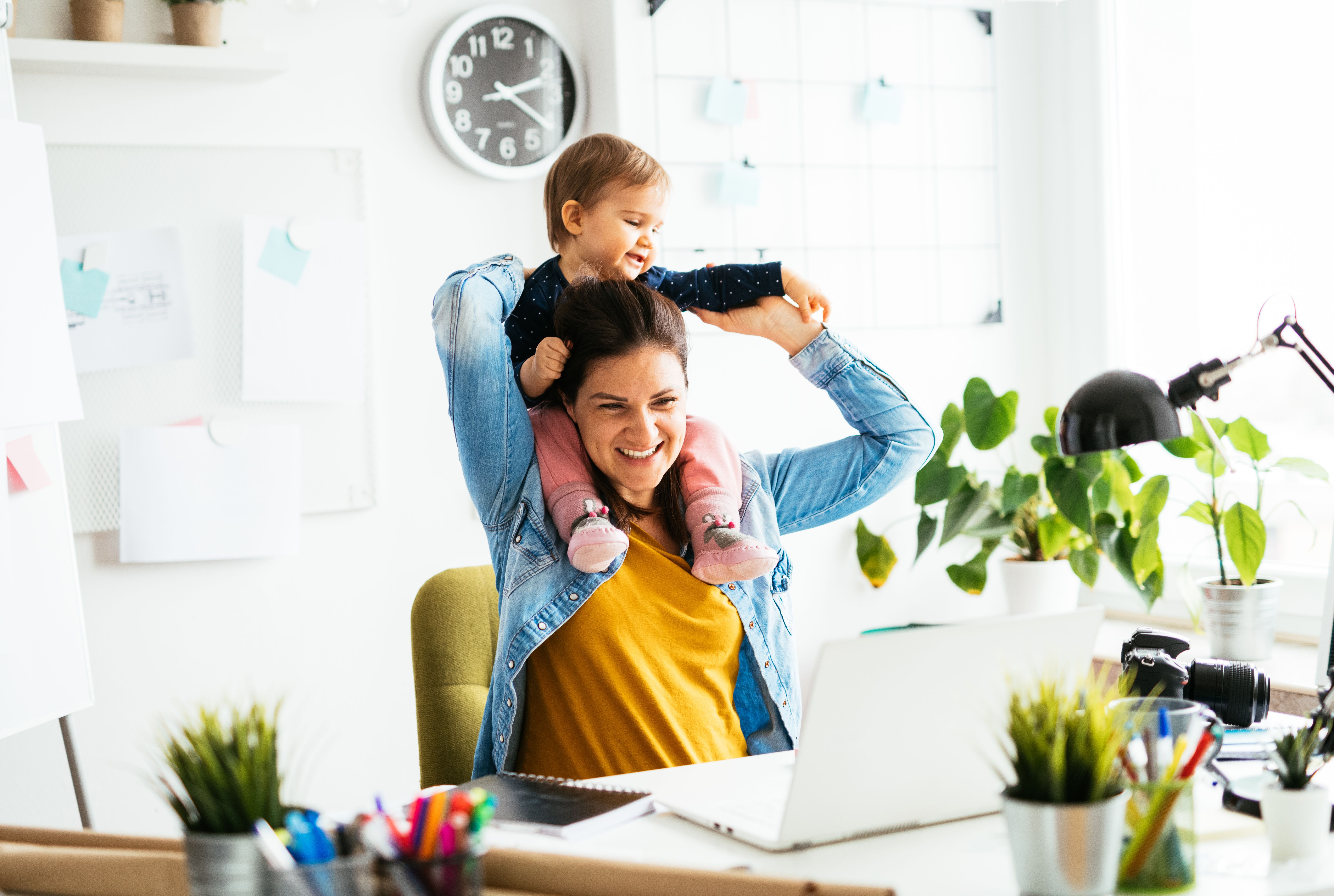 Portrait of busy woman working from home with baby