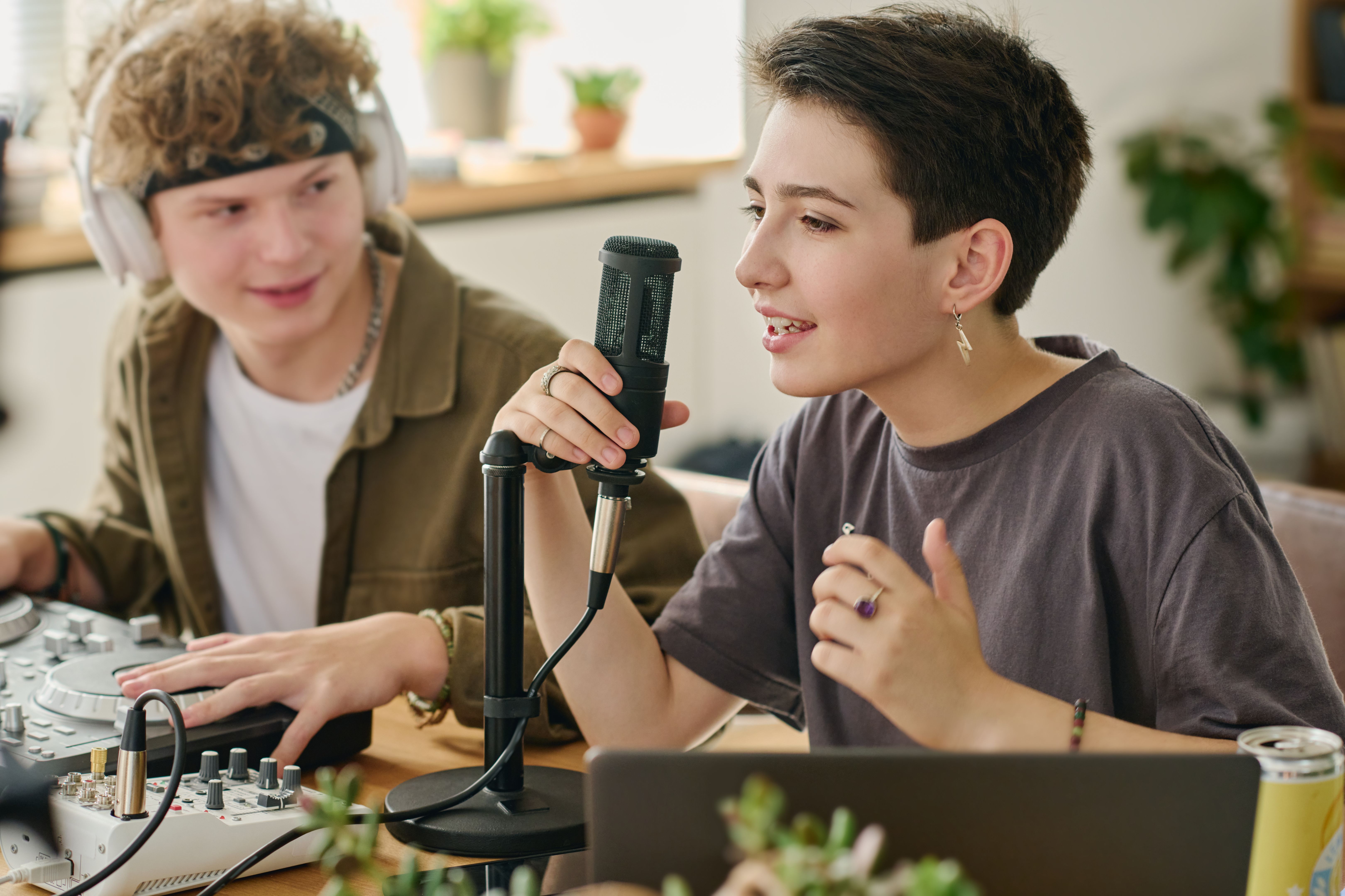 Cute teenage girl sing in microphone during broadcast from home