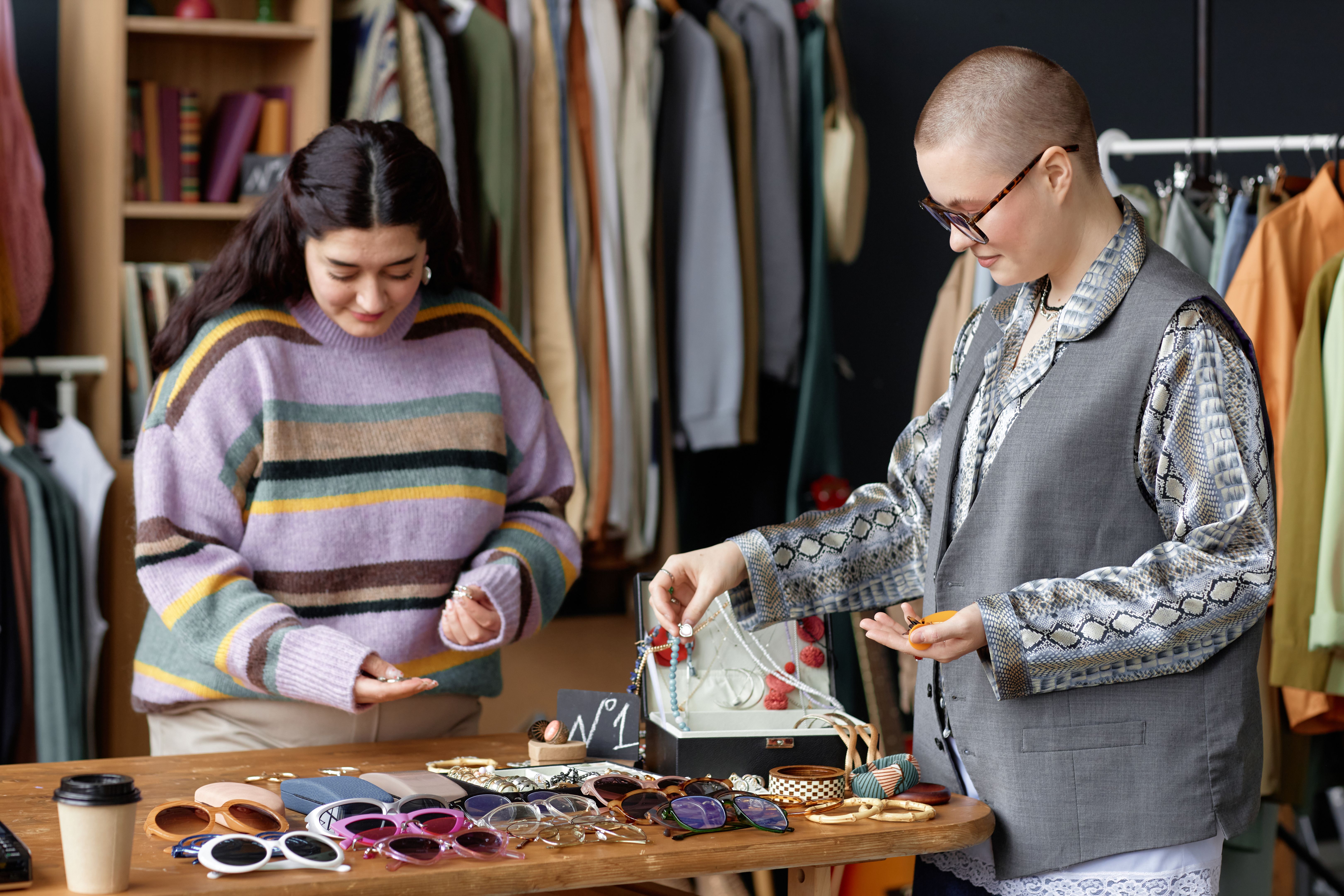 Female Stylist and Client Choosing Vintage Jewelry at Thrift Store