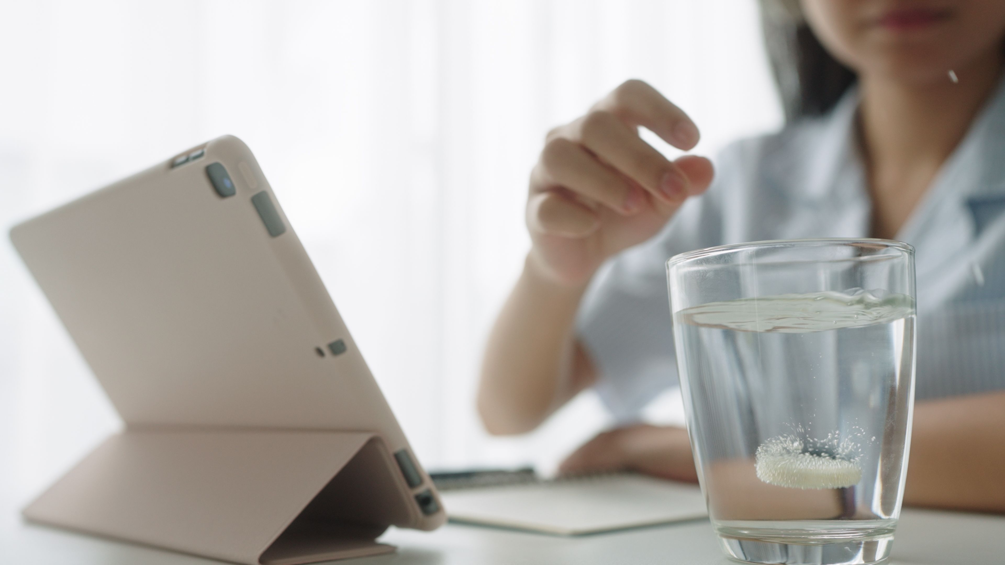 Teenager taking a vitamin while working.