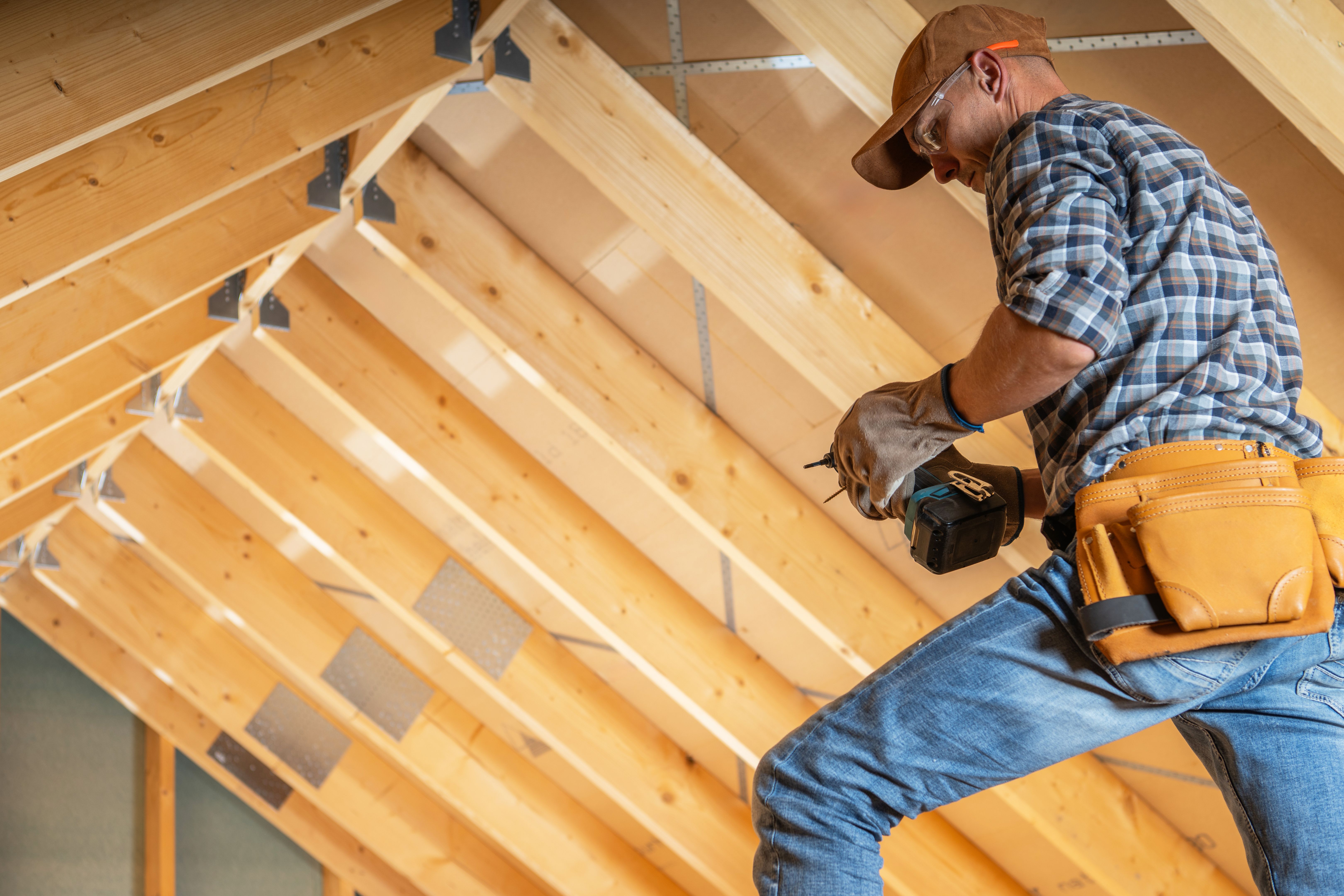 Construction Worker Installing Beams in an Attic Renovation Project