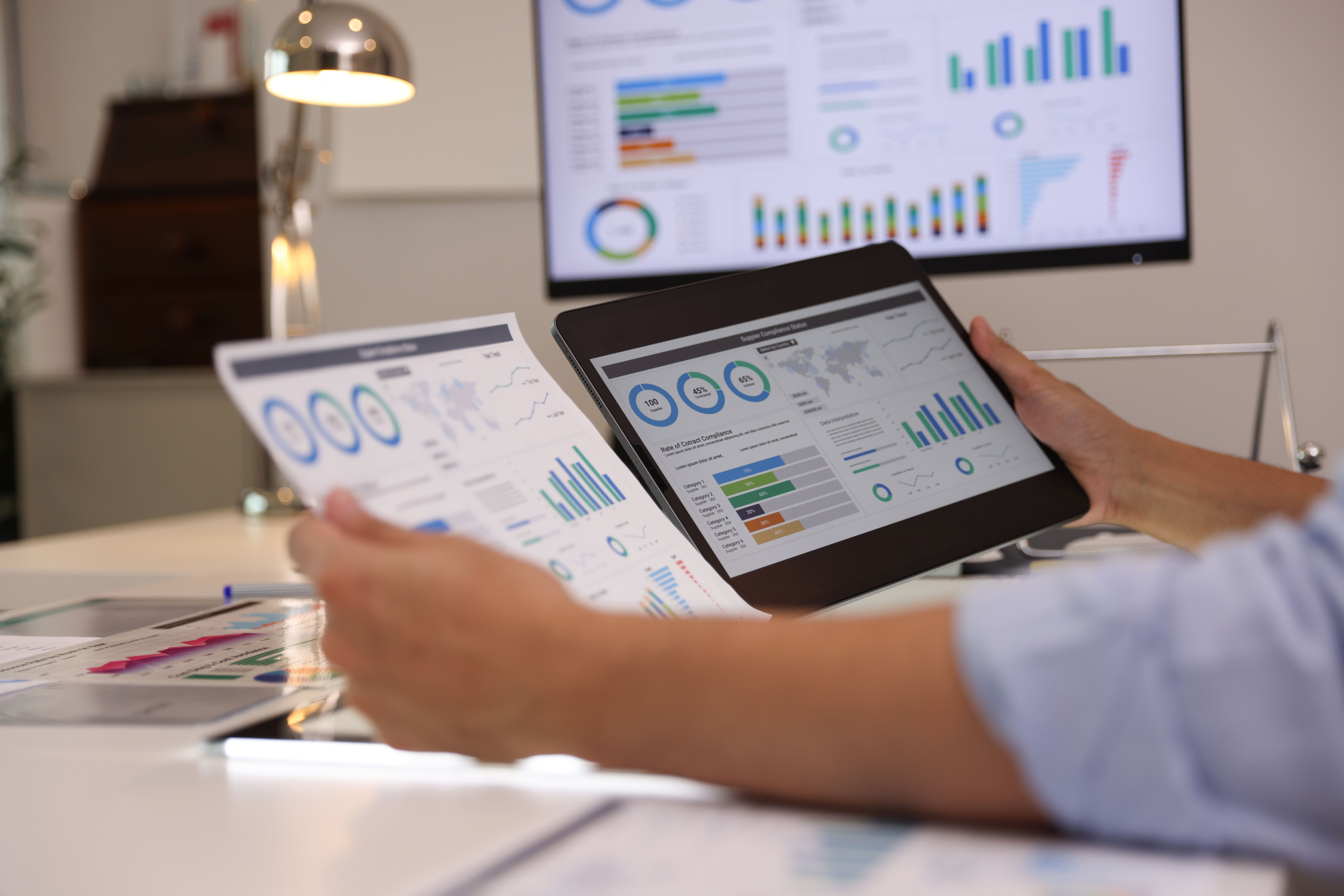 Close-up side young businessman working to compare the report at the office, on the multi report for presentation.