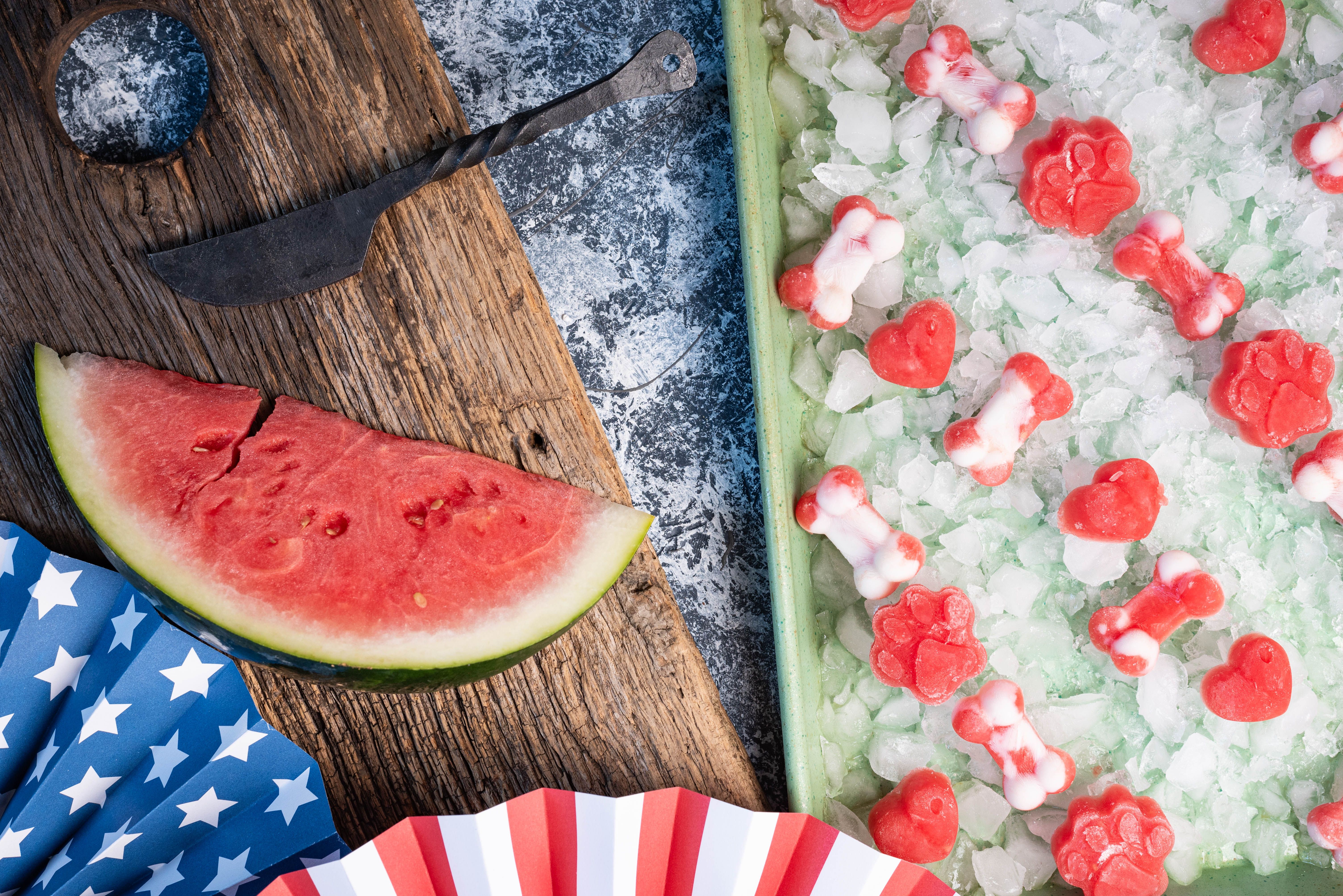 Frozen, watermelon dog treats on ice in a green sheet pan. Frozen, watermelon dog treats on ice in a green sheet pan.