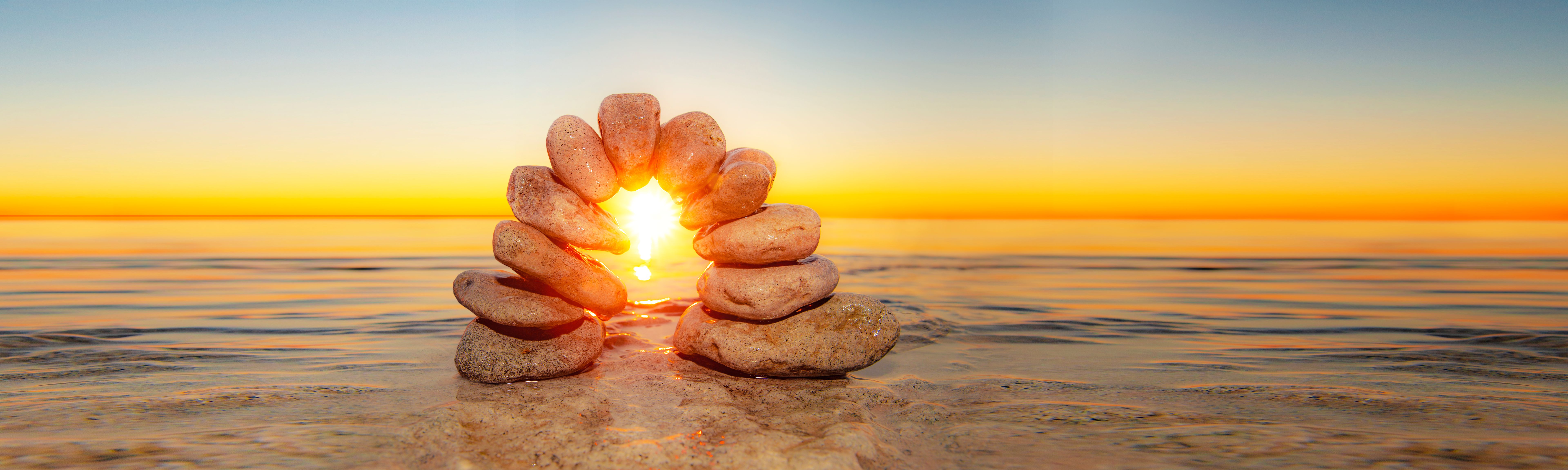 Stone arch in water at sunset