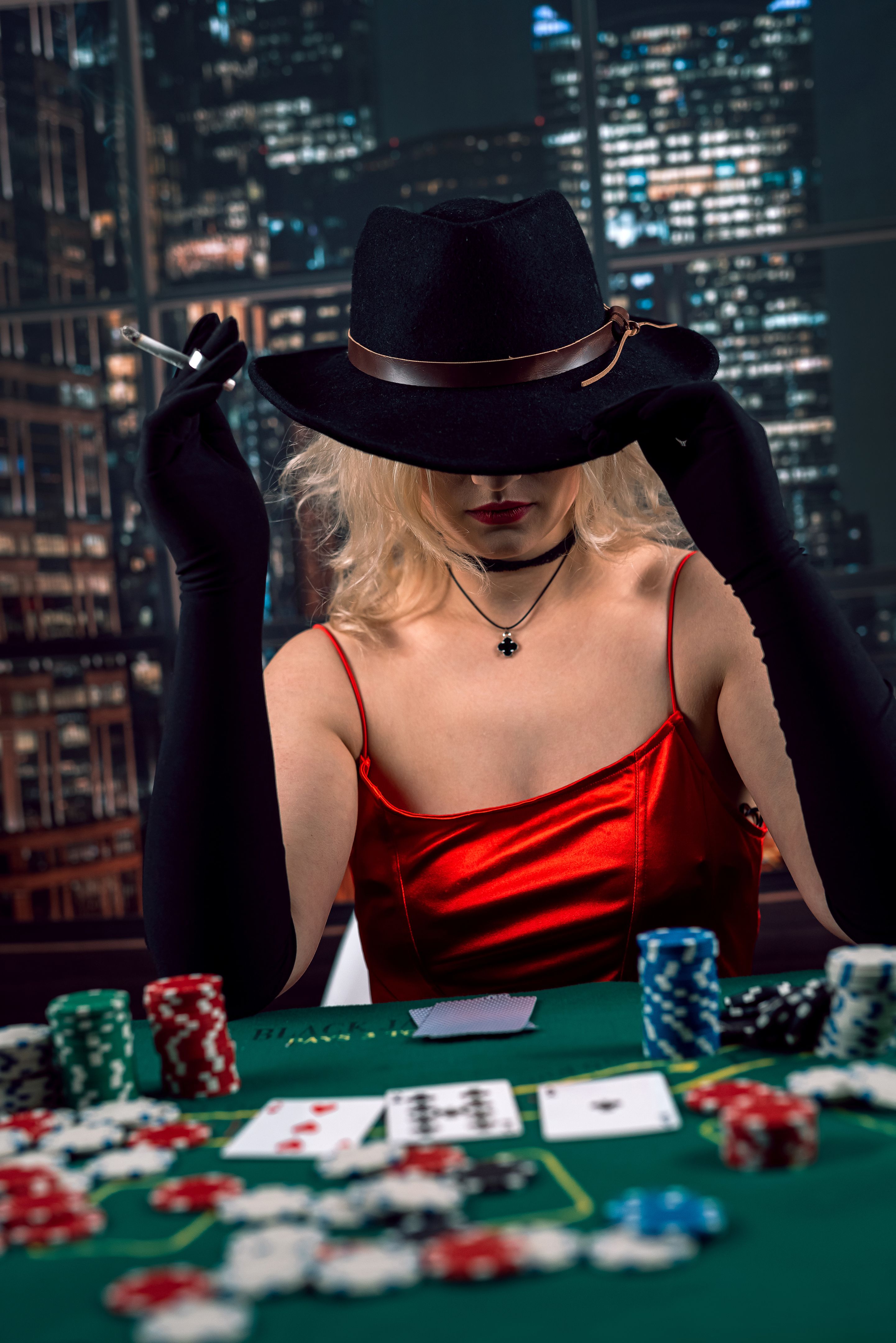Young woman wear red evening dress playing poker at casino Young woman wear red evening dress playing poker at casino