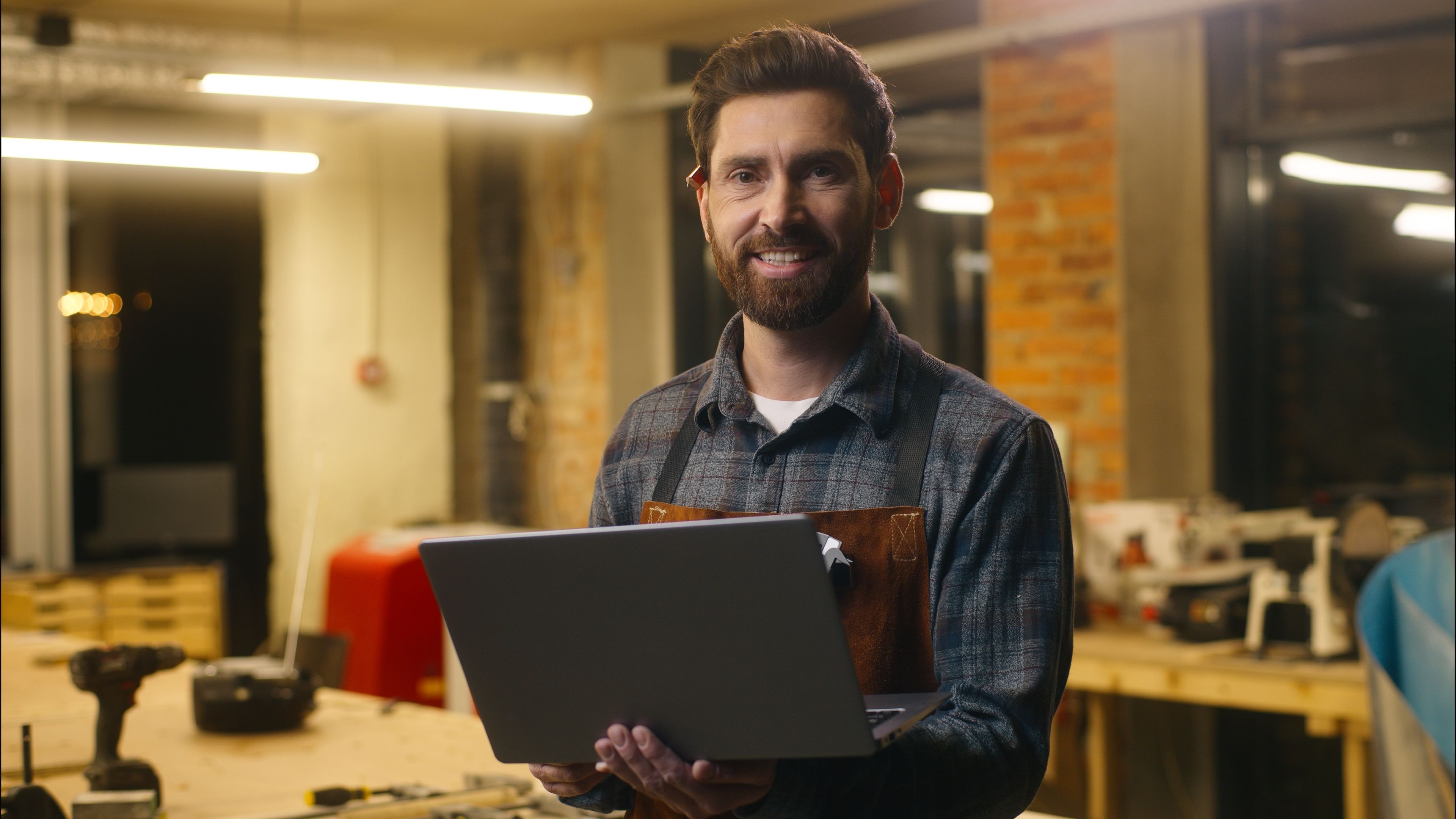 Positive Caucasian wood master man typing laptop online in workshop small business craftsman guy using computer device male joiner worker smile carpenter virtual shopping application Internet website