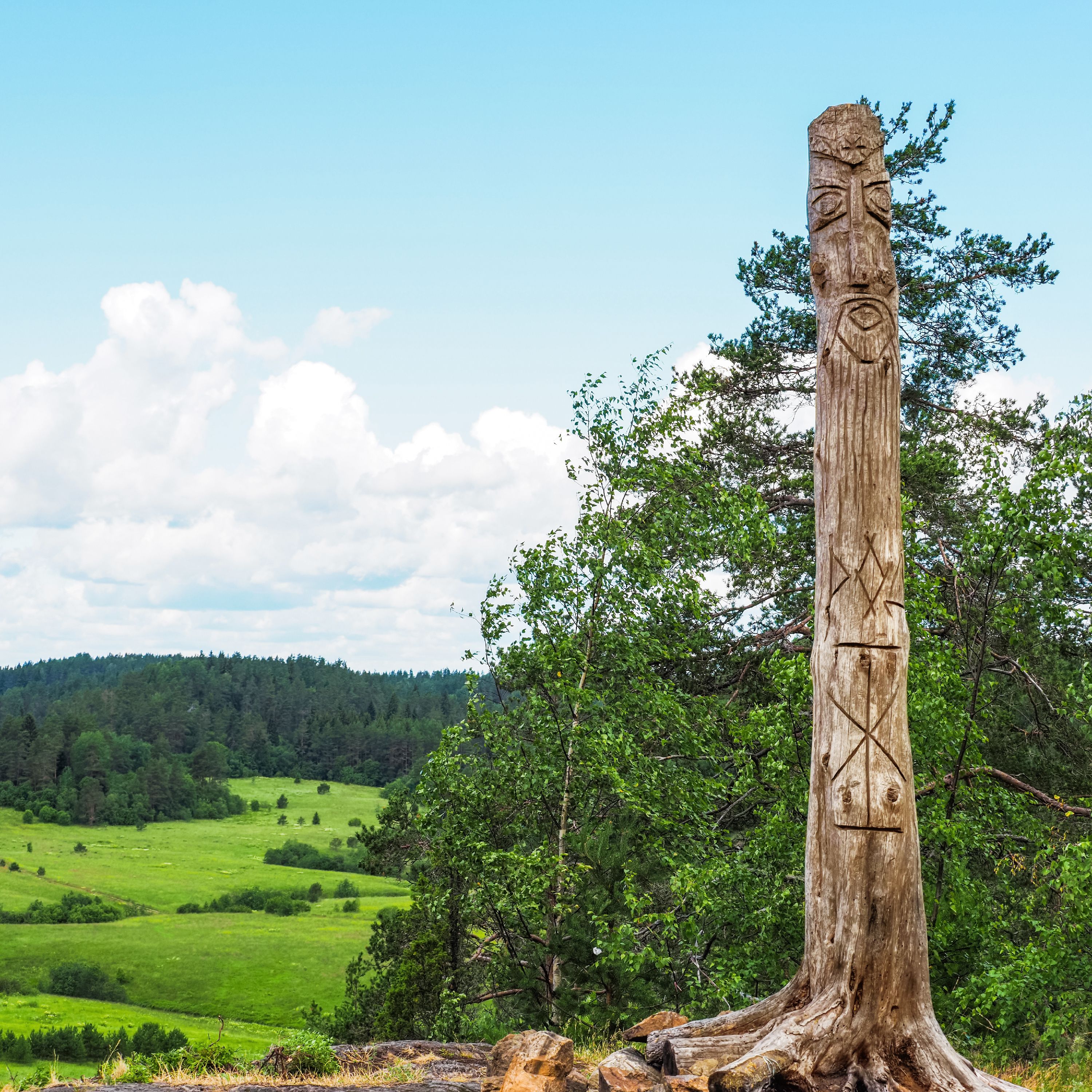 Pagan temple on Akhmavaara rock with wooden idol. Image of pagan god is carved from trunk tree, Karelia, Russia
