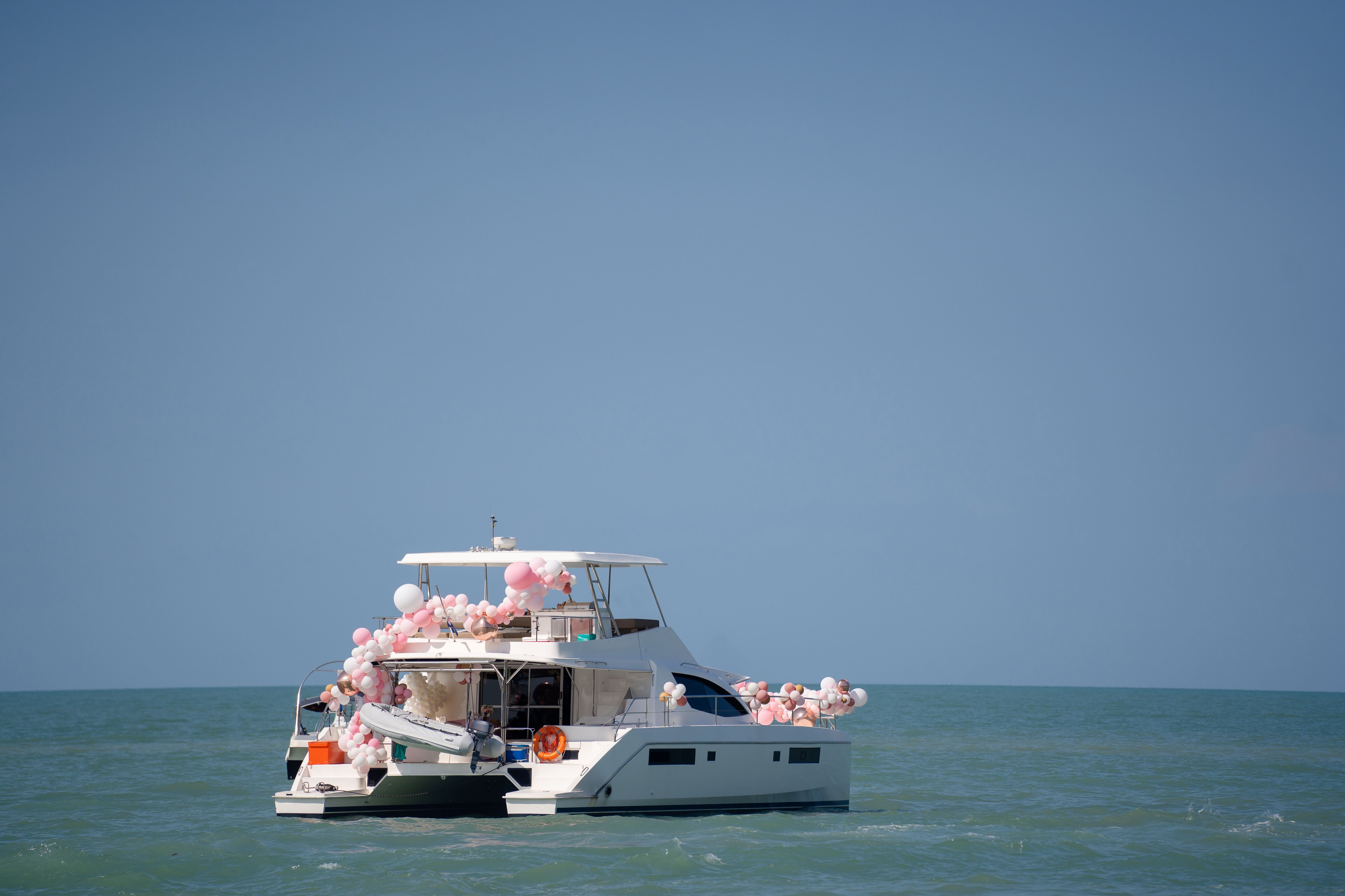 Private yacht adorned with festive balloons on the open sea