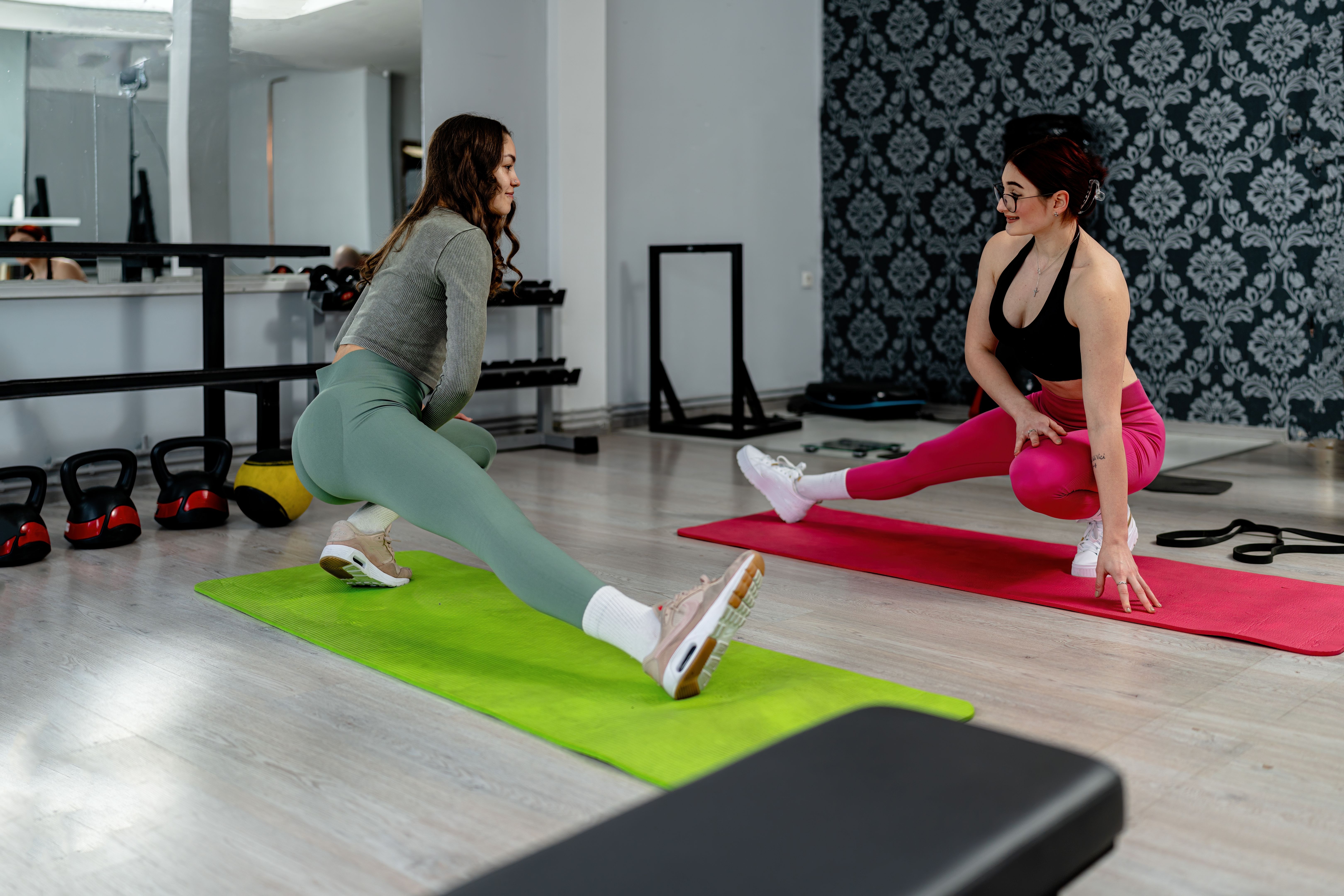 Women stretching on yoga mats during gym fitness session Women stretching on yoga mats during gym fitness session