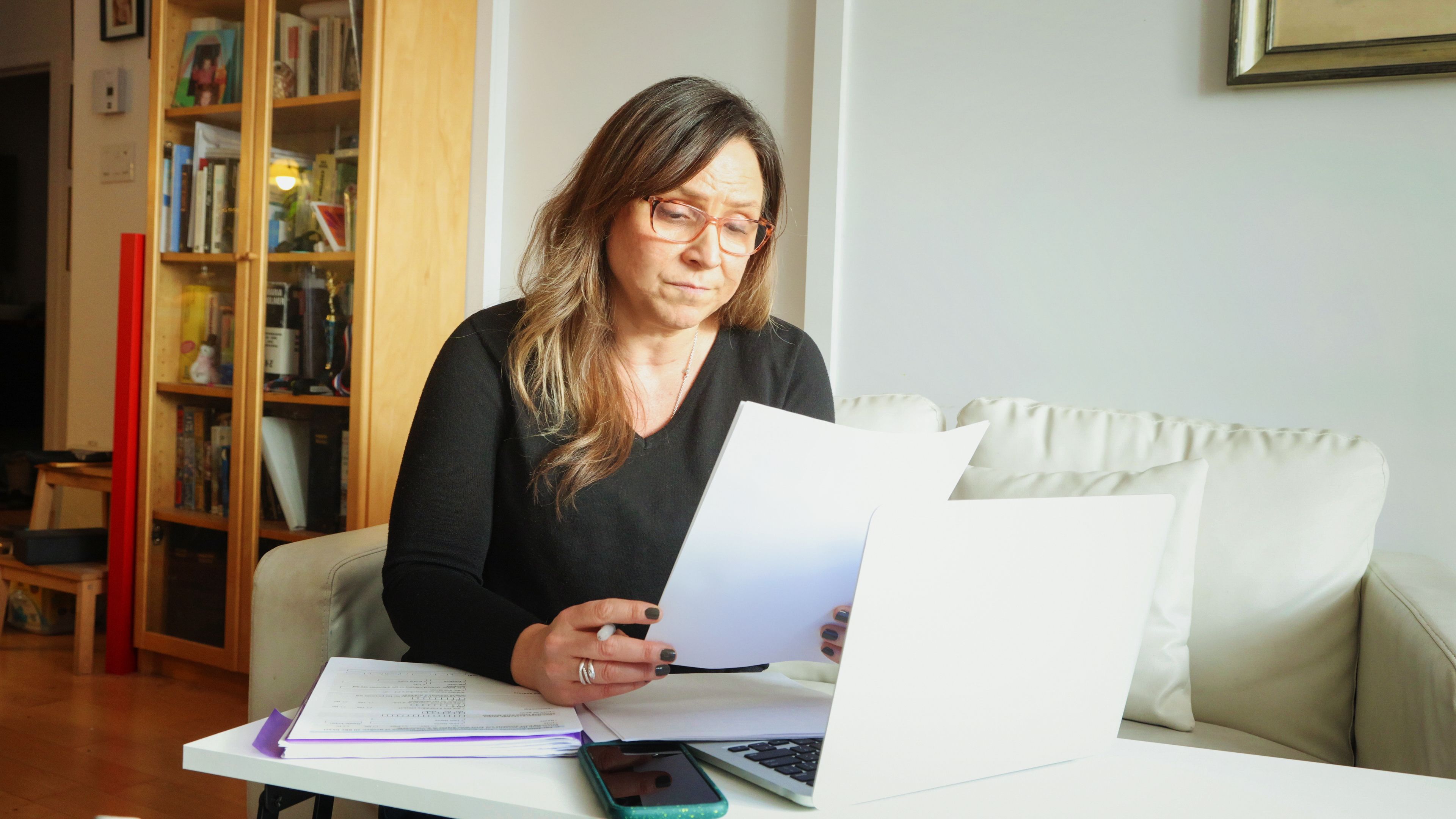 Mature female lacking enthusiasm as she sorts out her finances at home Mature female lacking enthusiasm as she sorts out her finances at home