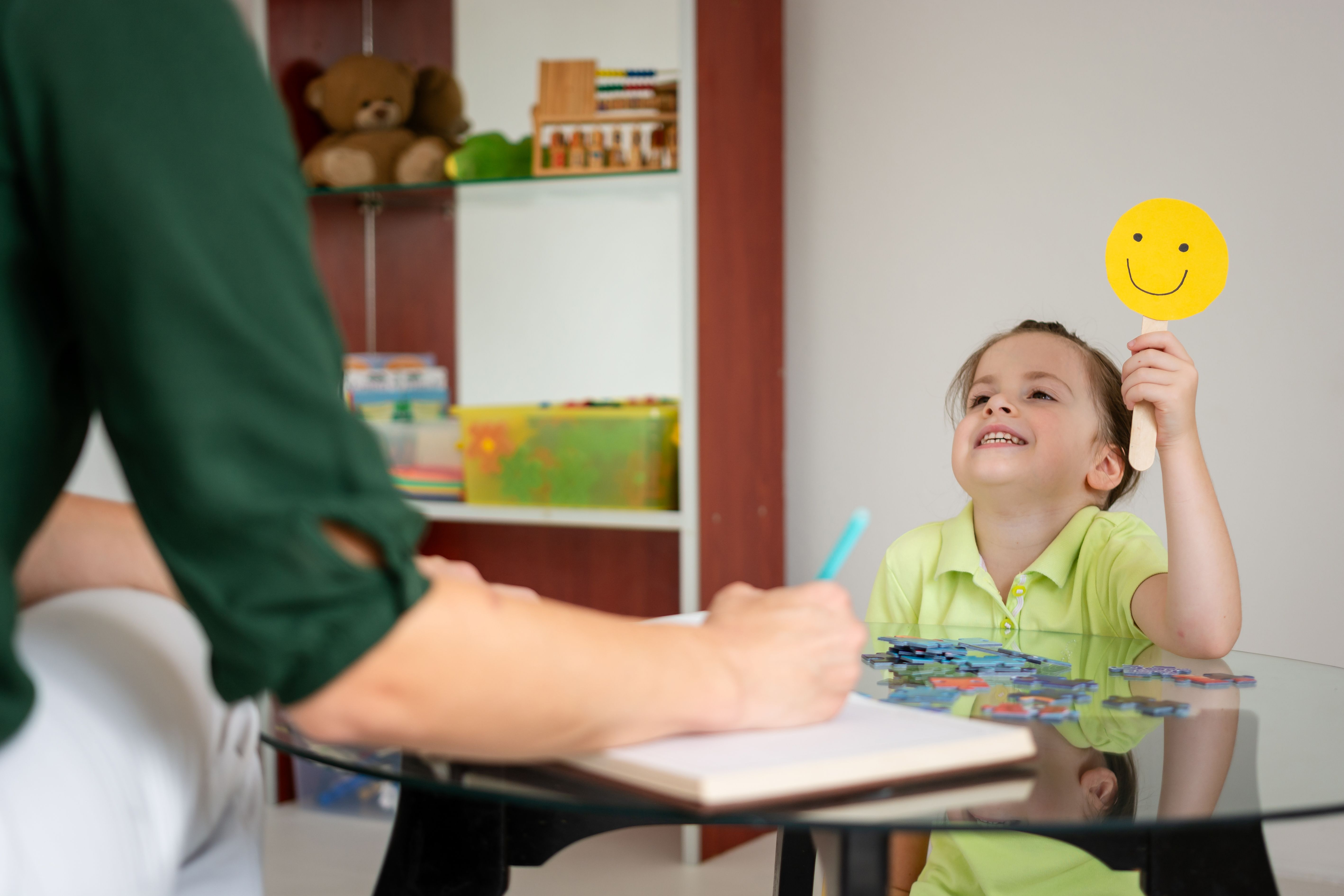 A little girl shows that she is happy while holding a smiley sign A little girl shows that she is happy while holding a smiley sign