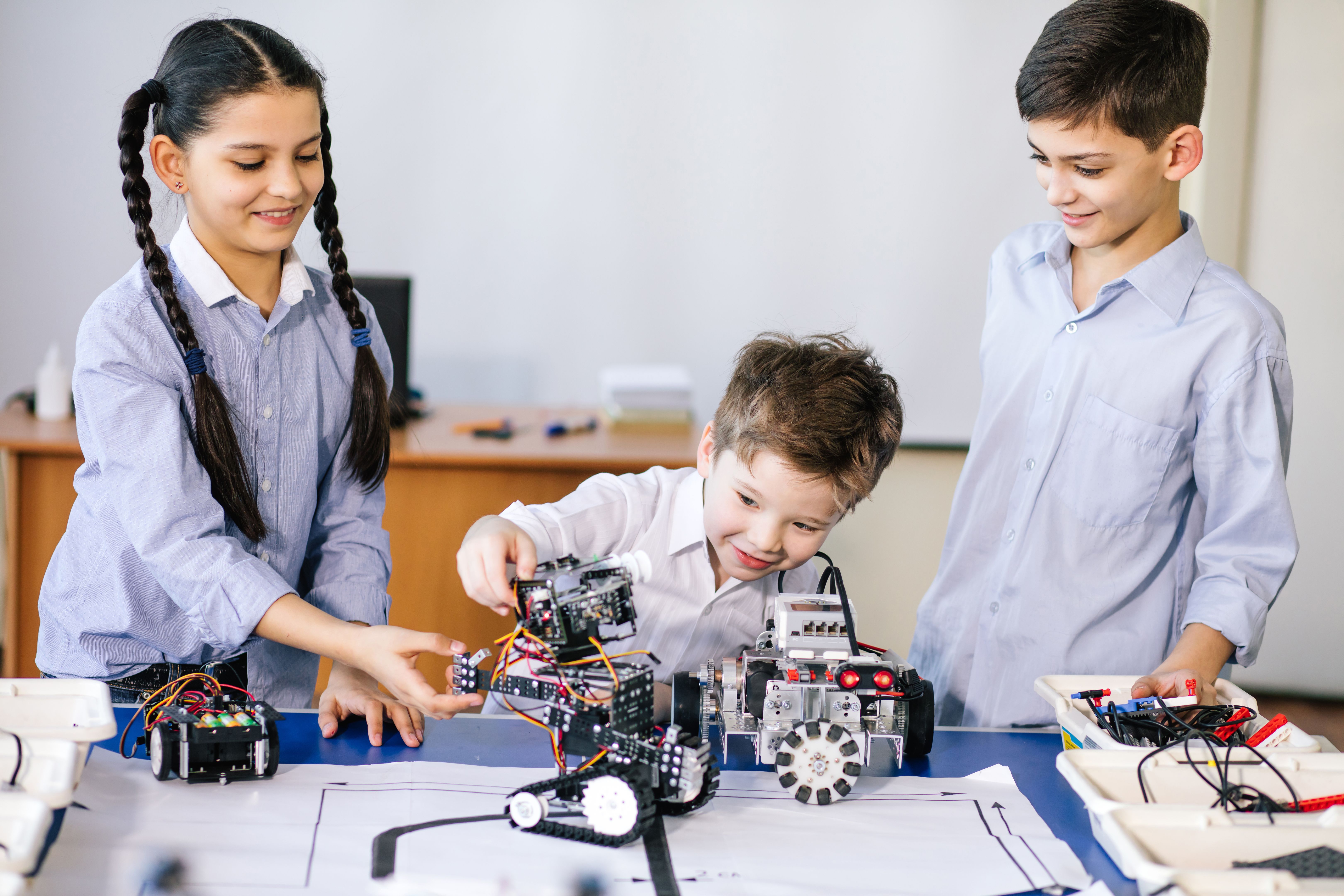 Kids playing with electrical robot while visiting robotics exhibition