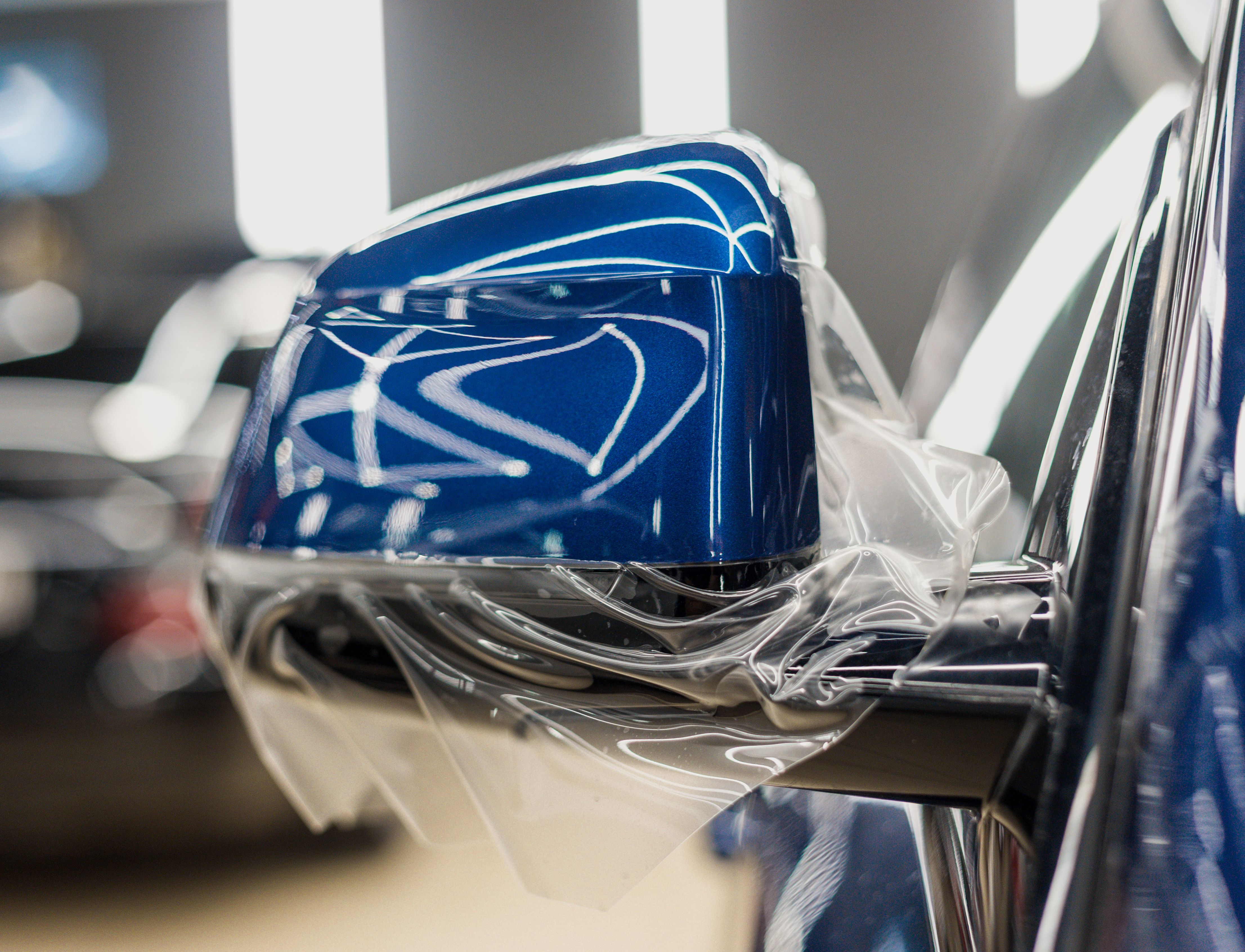 The process of installing PPF on the side mirror. PPF is a protective film for paint that protects the paint from scratches and gravel.Anti-gravity protection. PFF is installed.