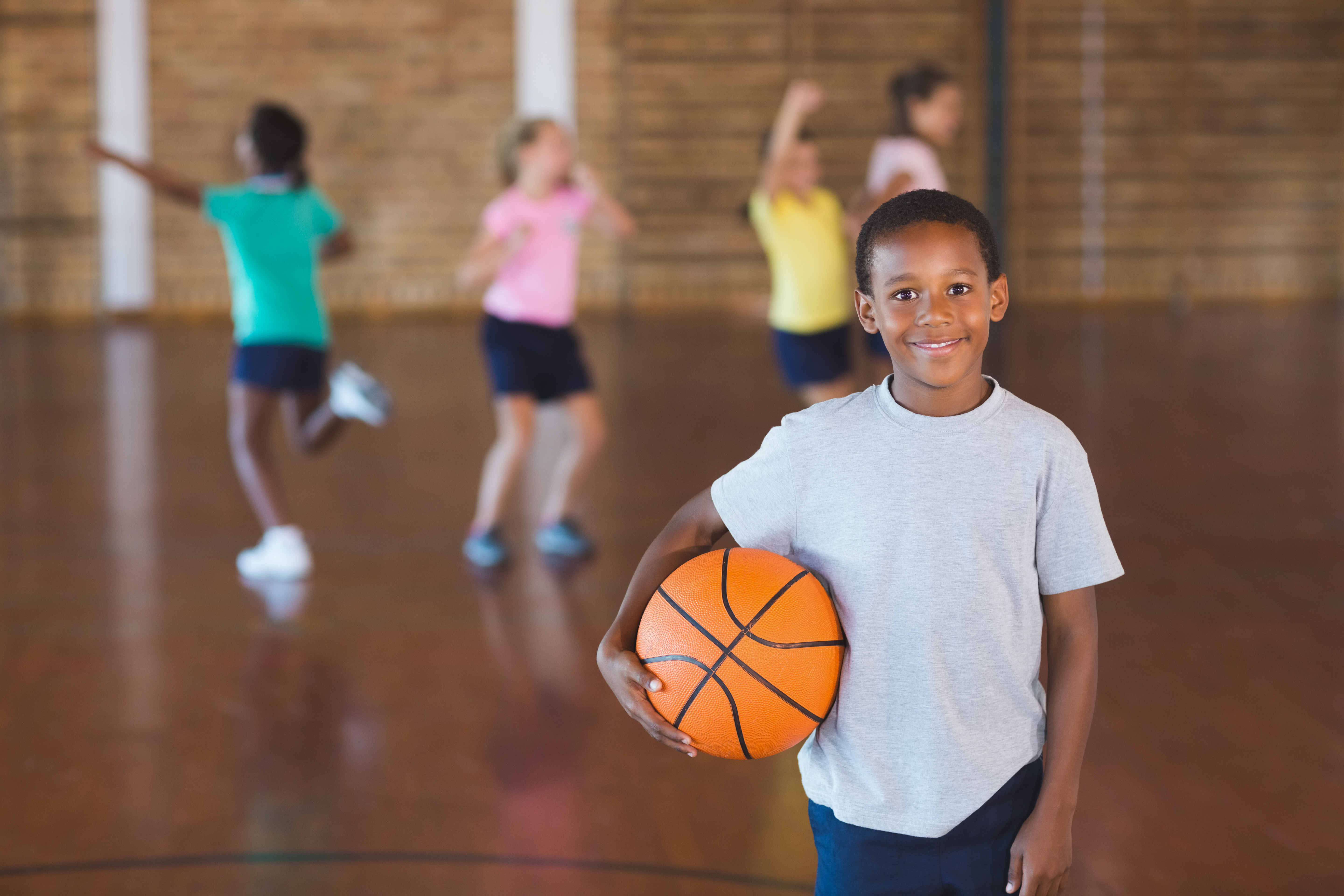 Boy standing with ball in basketball court Boy standing with ball in basketball court