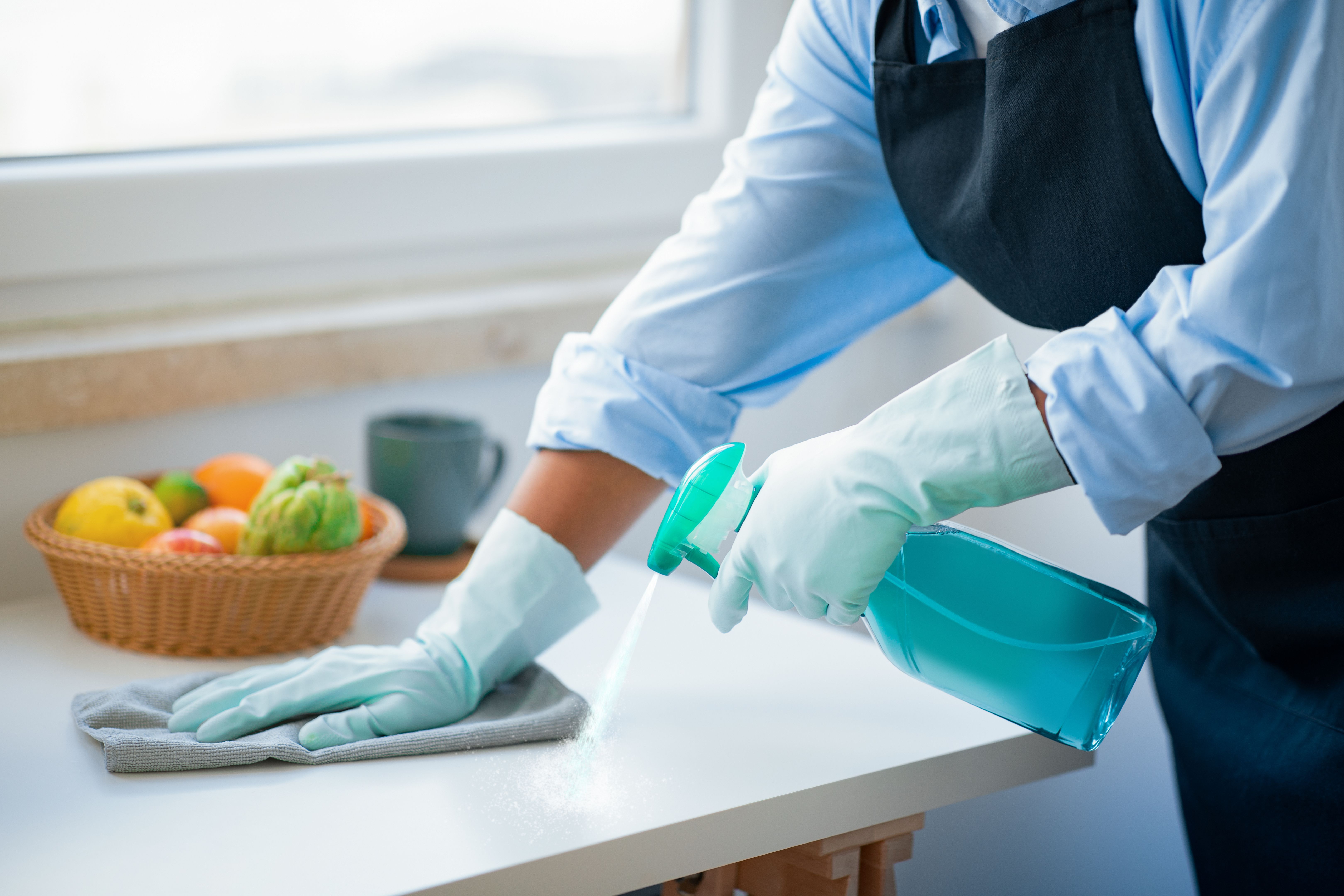 Unrecognizable maid hands cleaning kitchen, house-keeping service concept