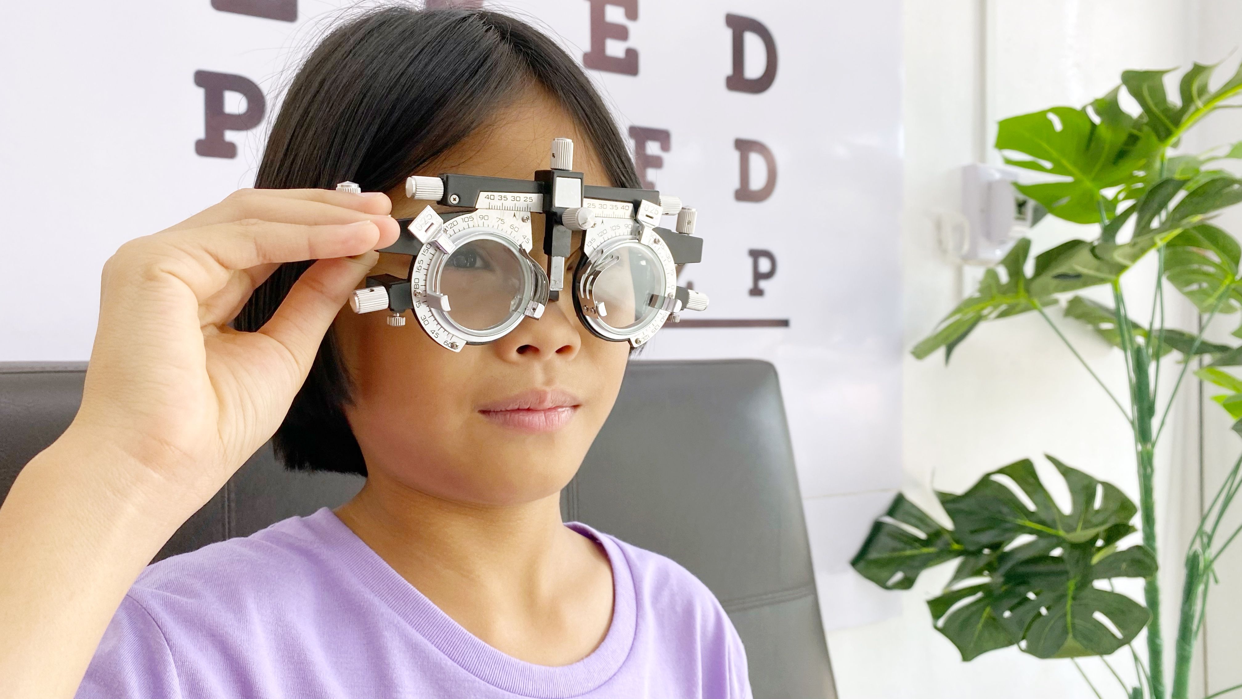 Eye test, Child wearing eyeglasses for medical eye test in clinic , eye exam, eye test concept, kid eye test