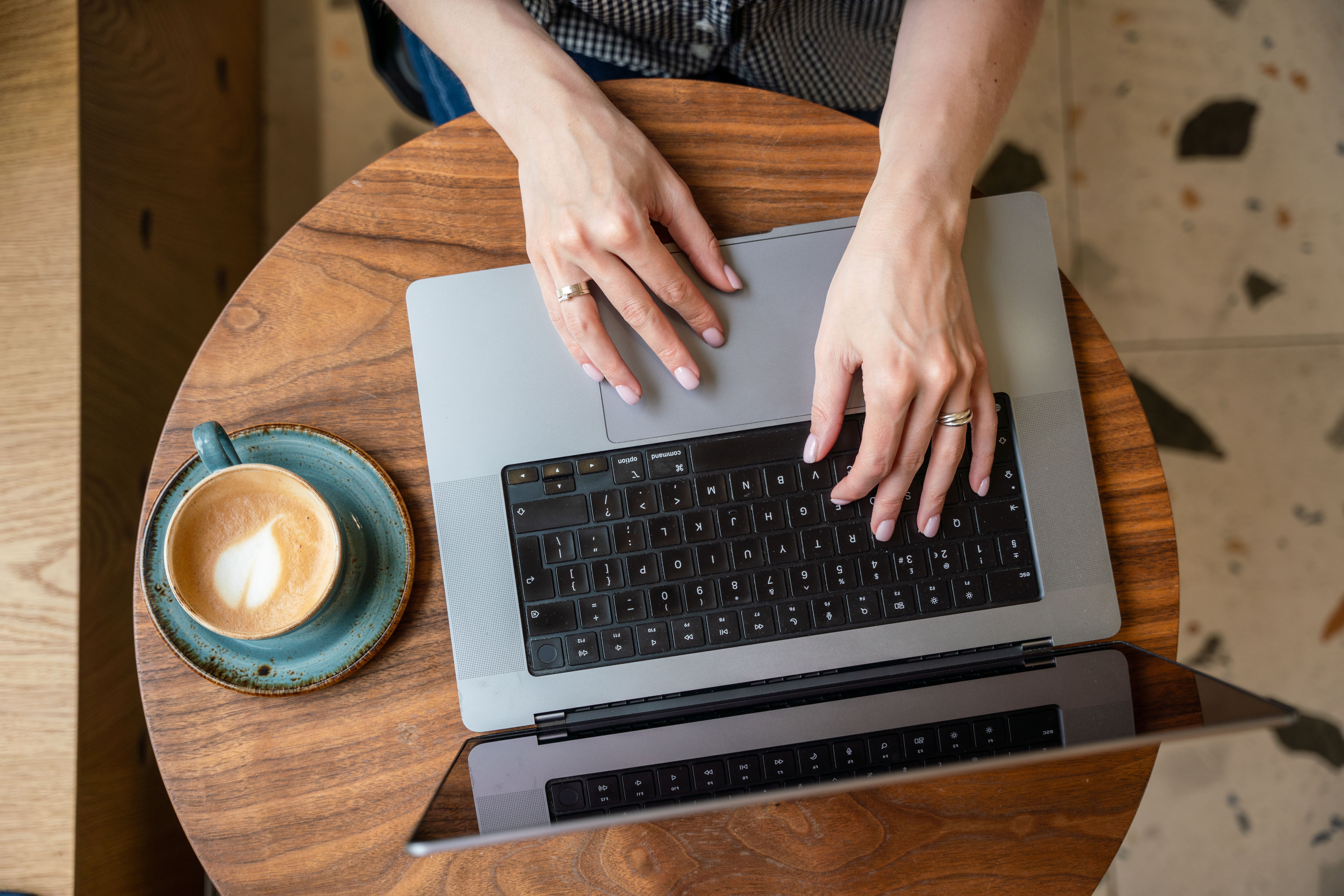 A woman uses laptop with blank black screen at the cafe table A woman uses laptop with blank black screen at the cafe table
