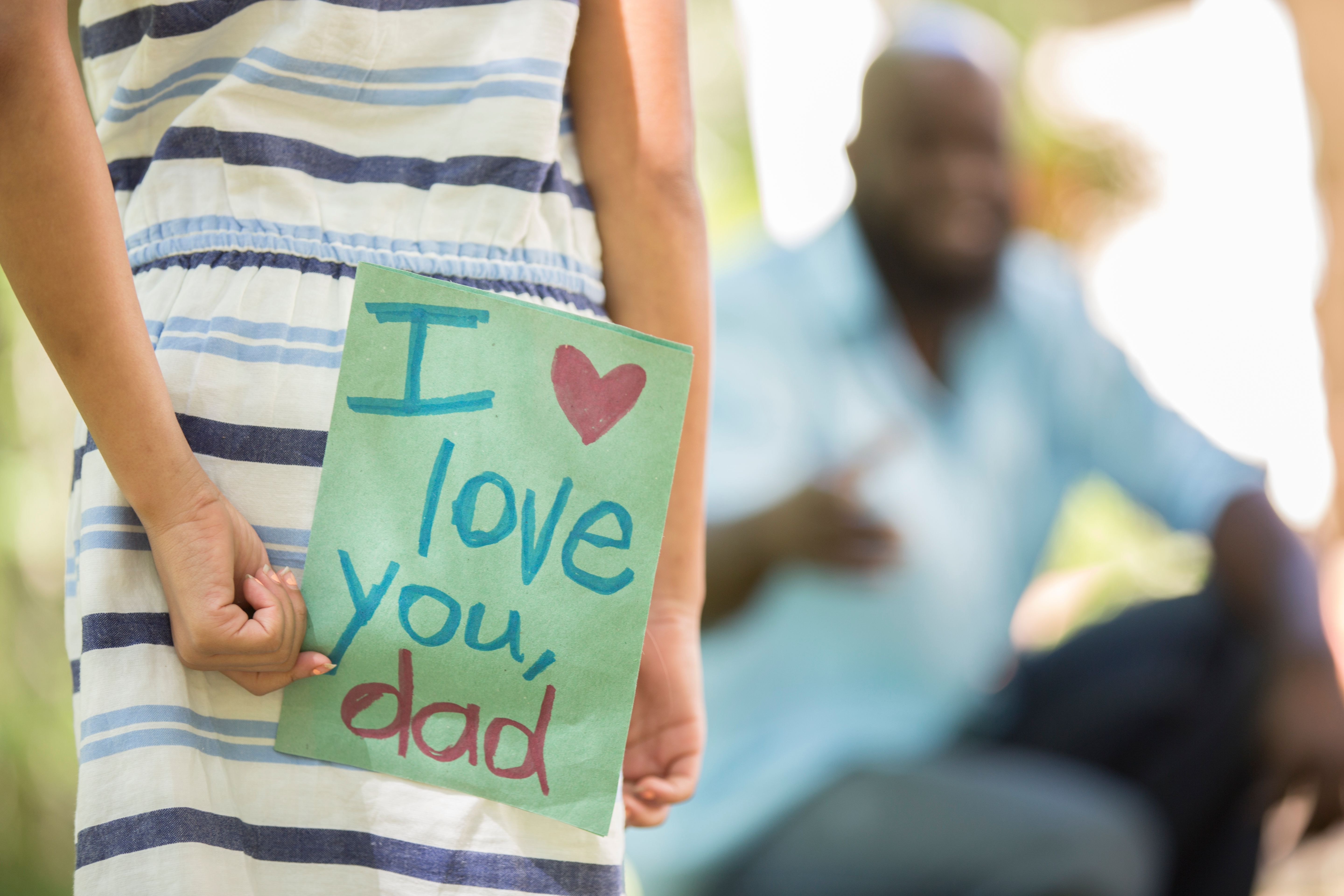 Happy Father's Day. Girl gives card to dad.