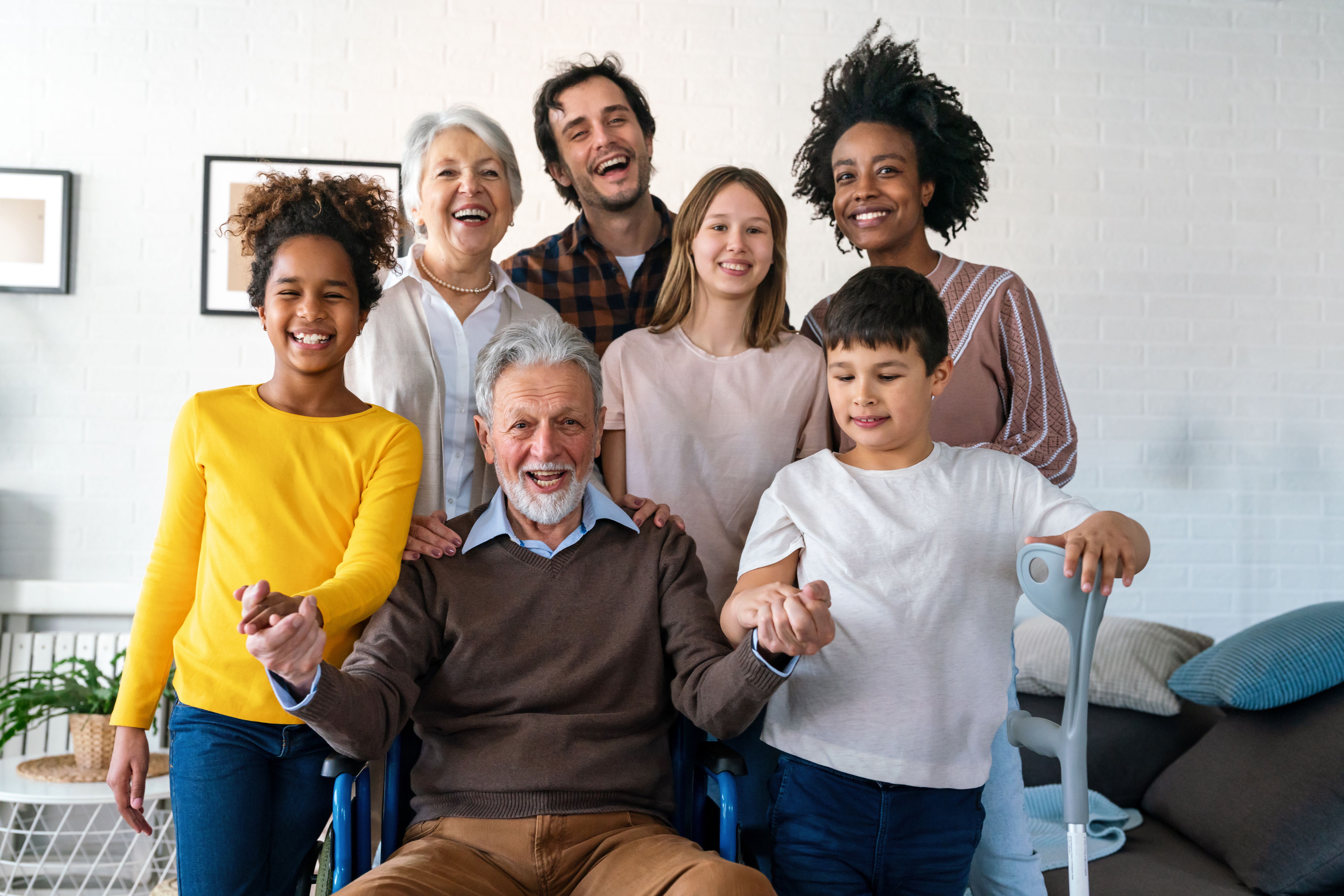 Multi generation, multiethnic family at home together, grandfather with disability