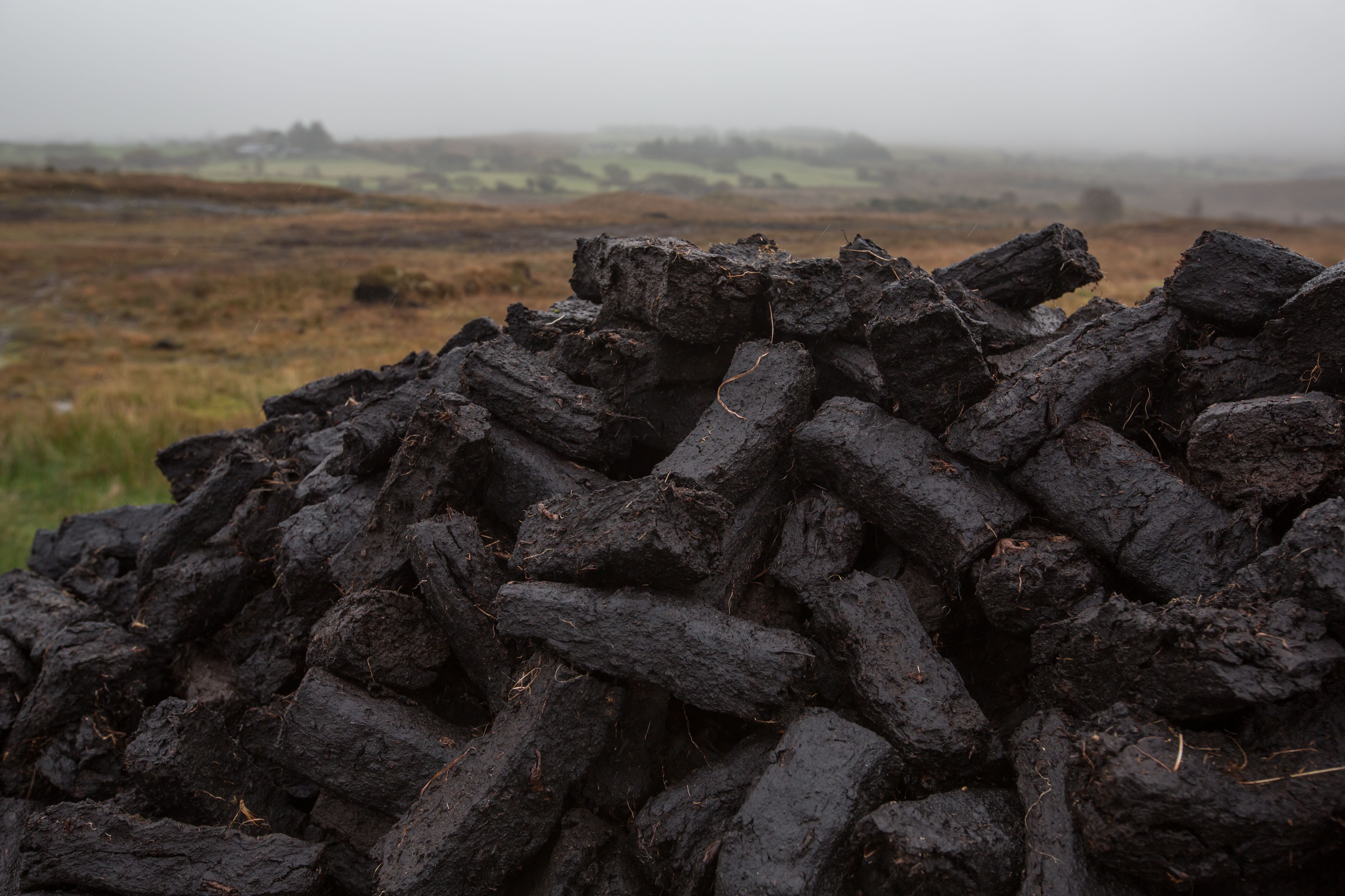 Pile of turf in misty Irish countryside