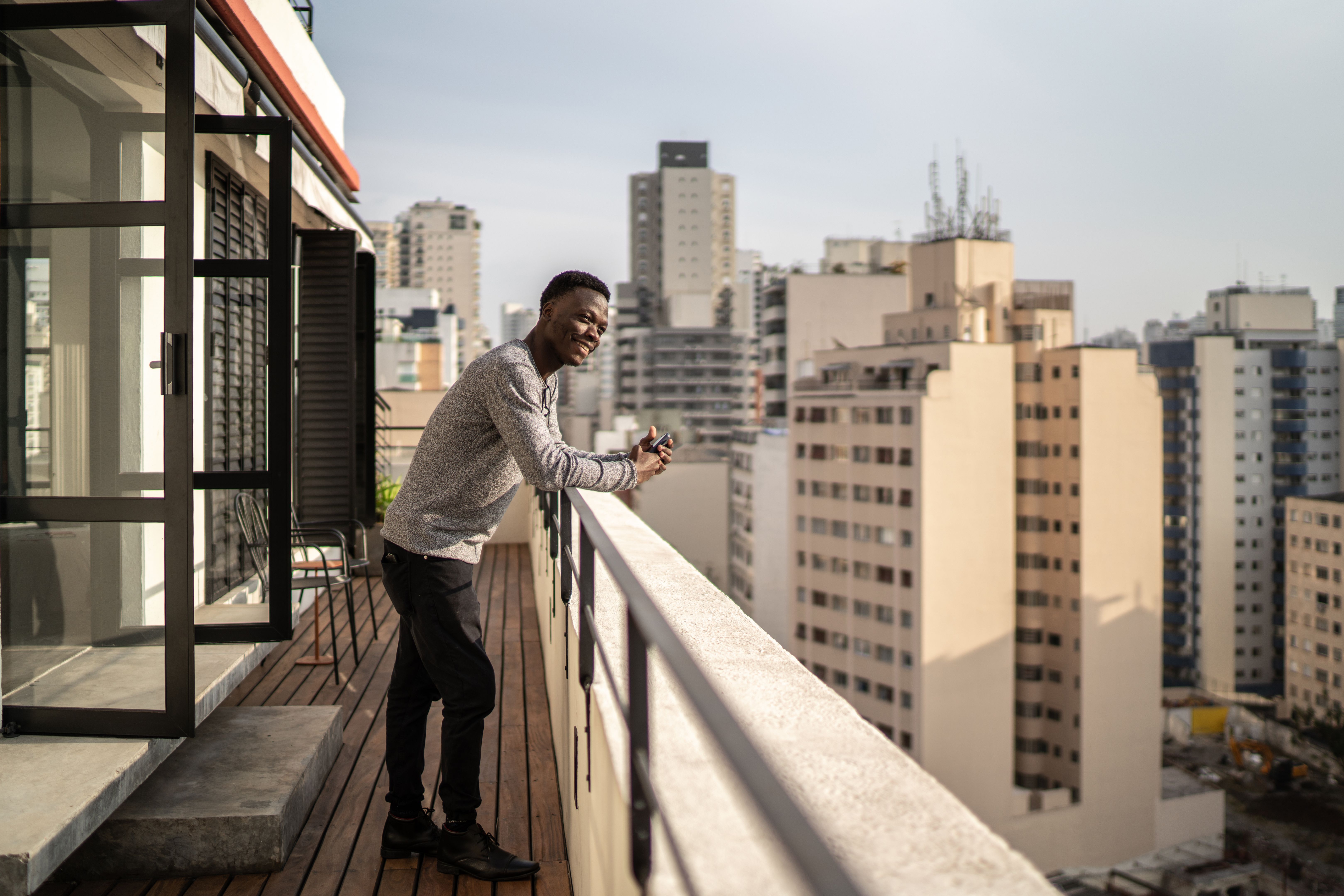 Young man contemplating from building terrace Young man contemplating from building terrace