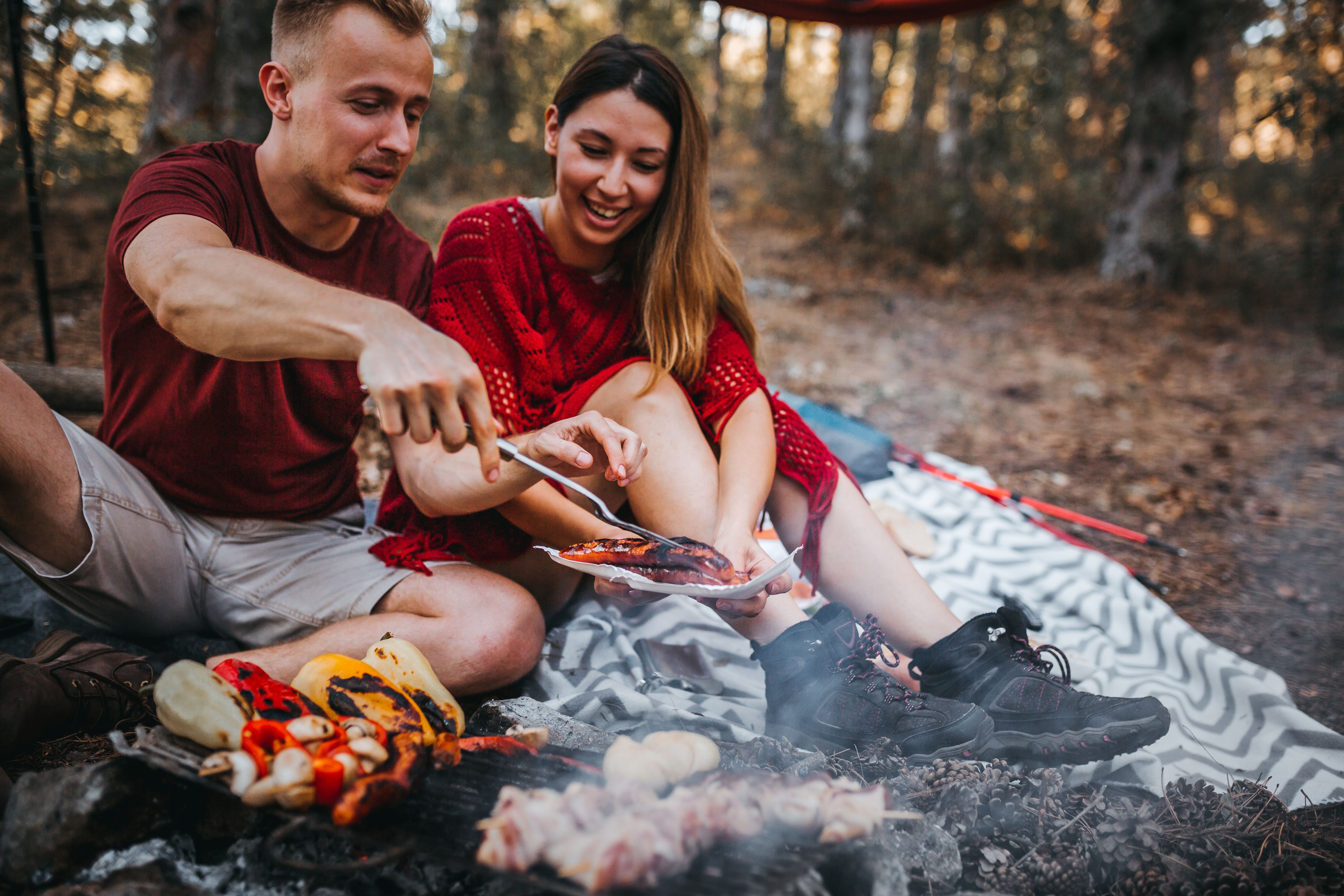 Couple preparing a food in nature, campfire