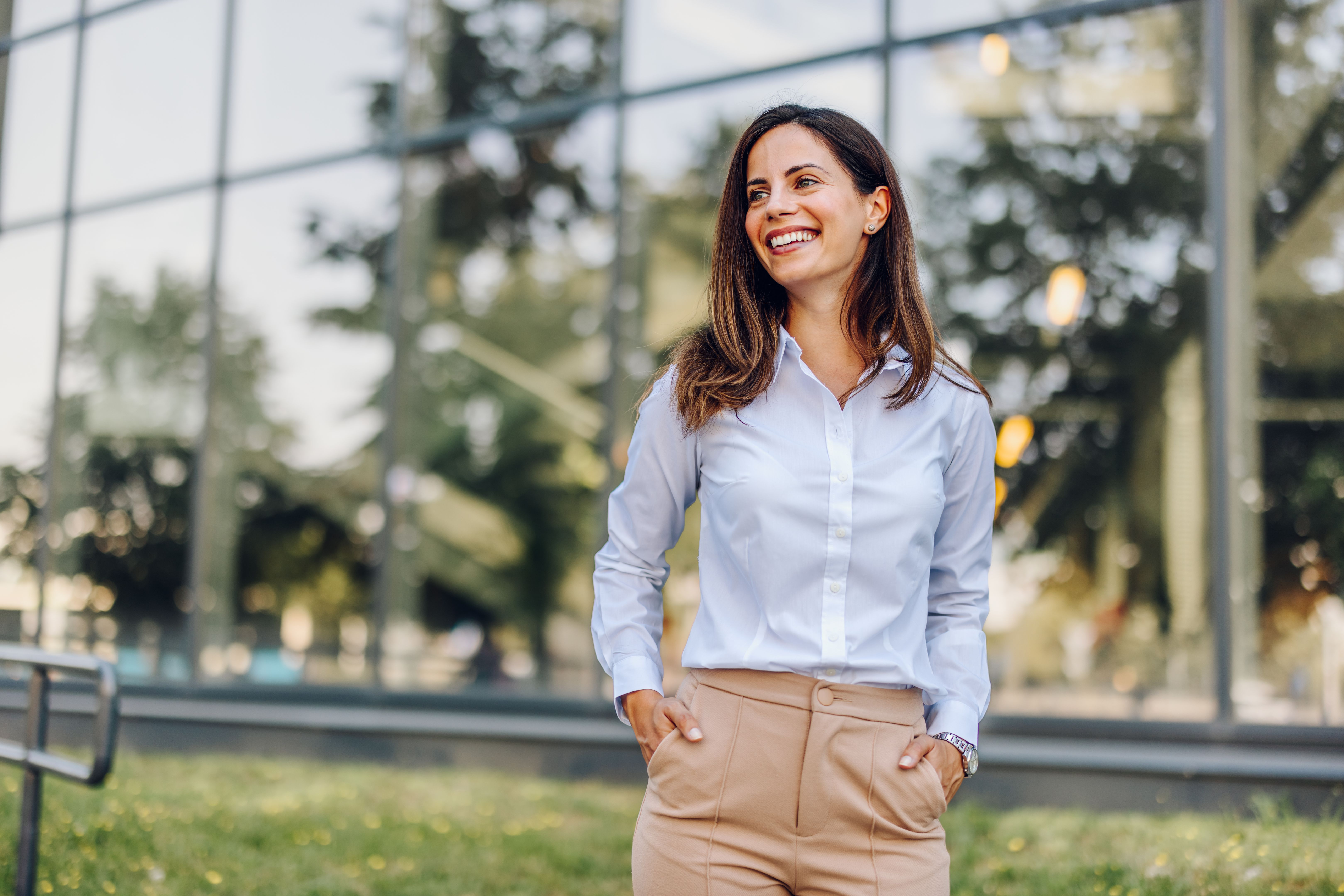 Portrait of a confident young businesswoman standing in front of the office building
