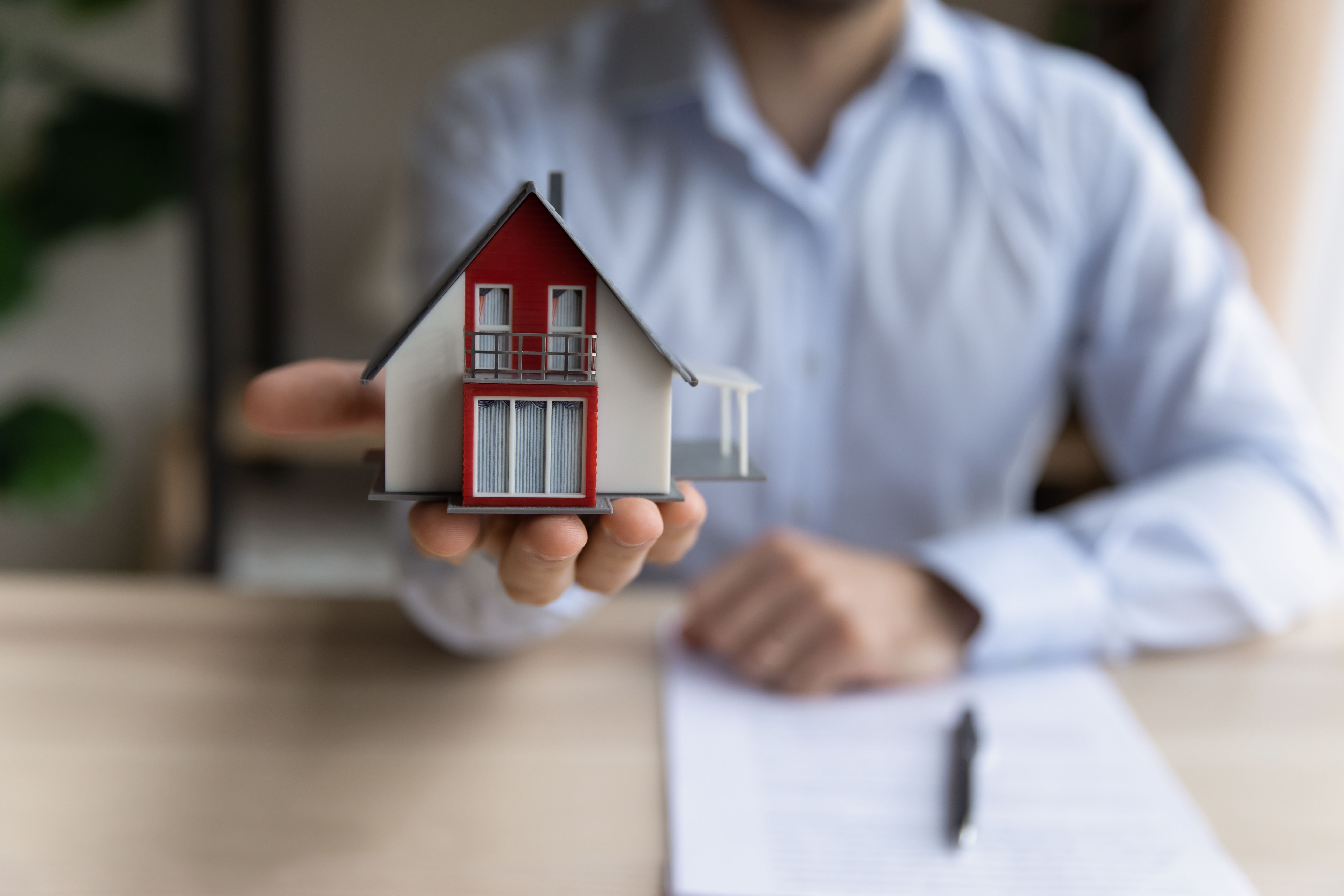 Homme agent immobilier tenant la disposition de la petite maison vue de près