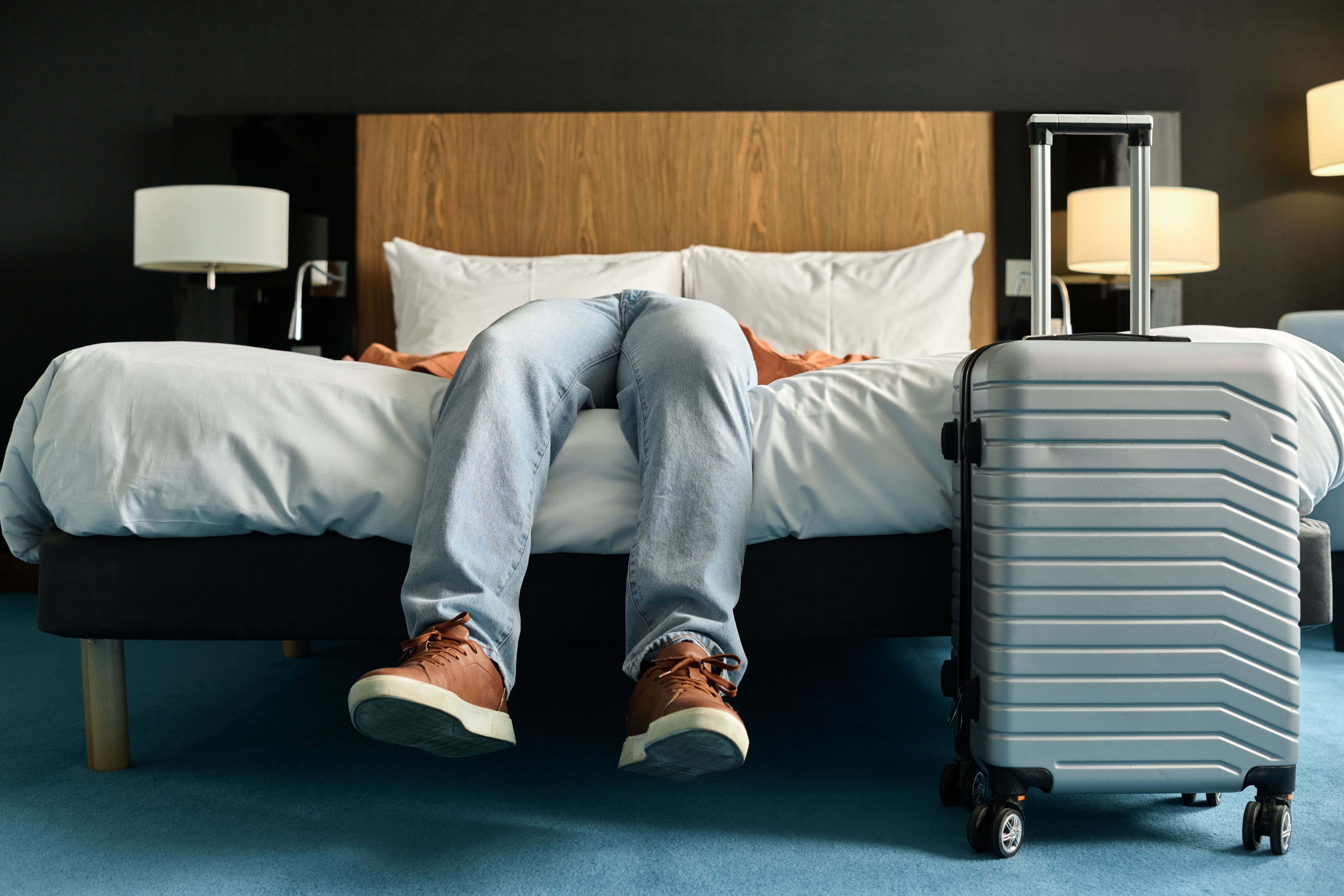 Man Lying on Bed in Hotel Room
