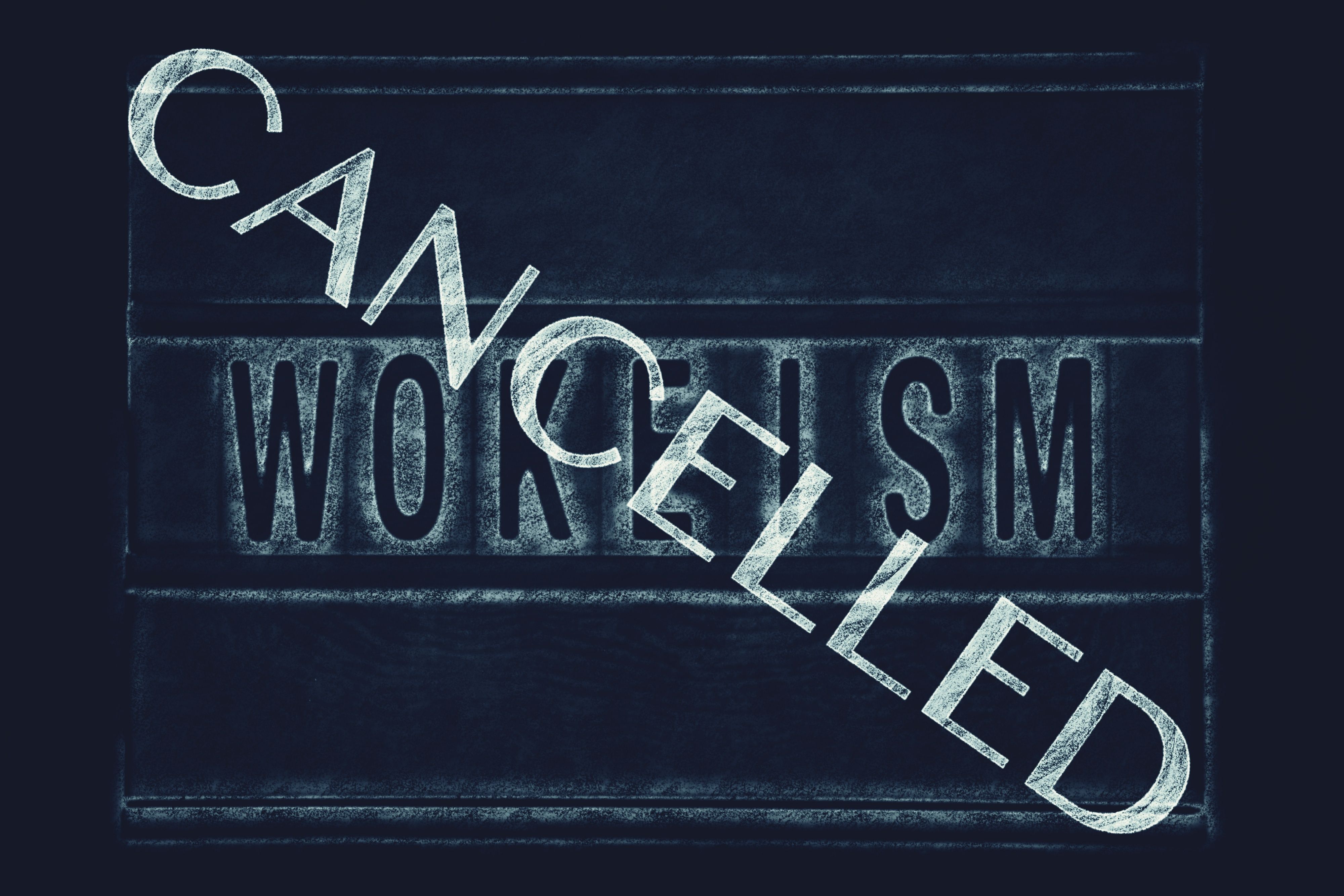 A Chalkboard Sign with the Word Wokeism and a Cancelled Stamp Across It A Chalkboard Sign with the Word Wokeism and a Cancelled Stamp Across It