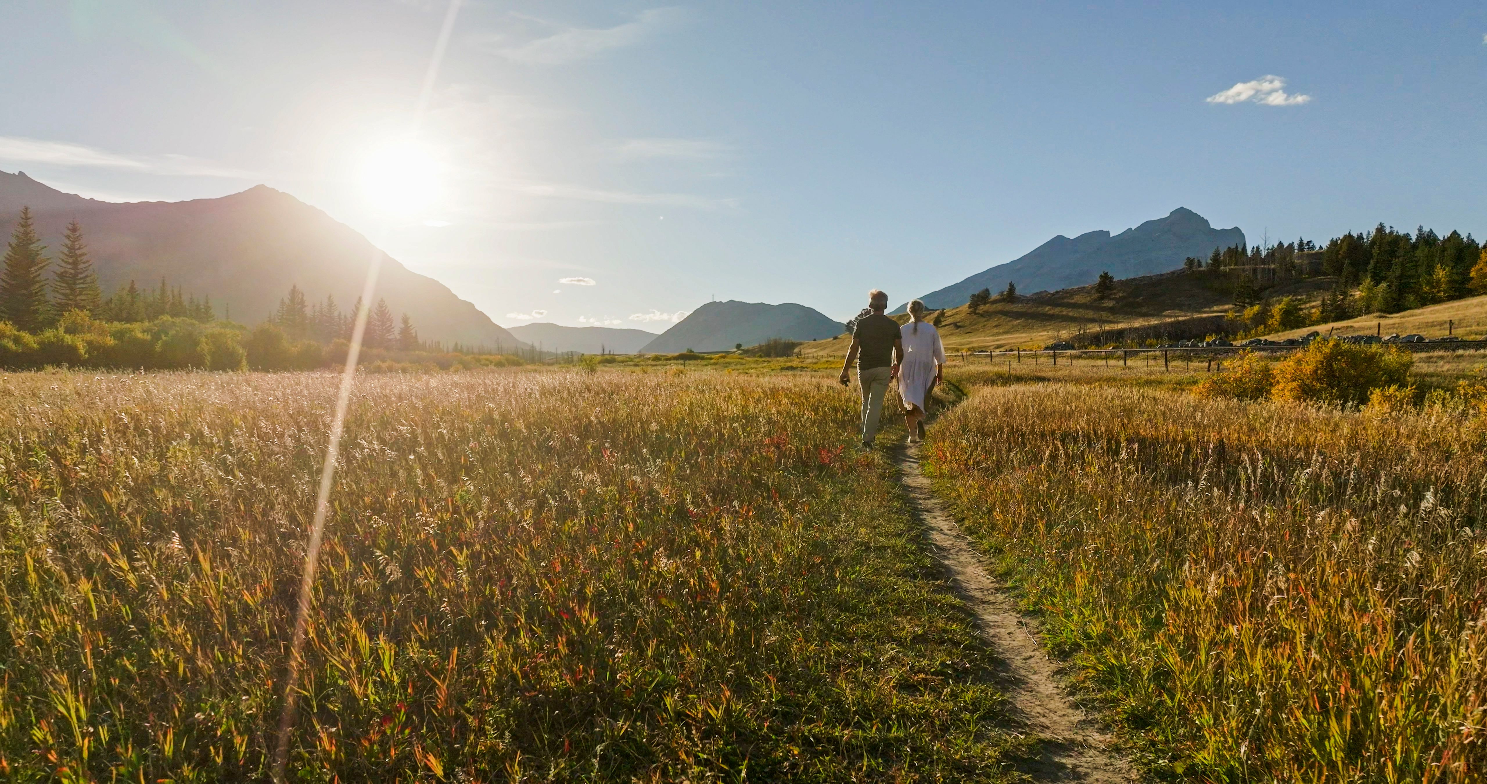 Mature couple hike in meadow in autumn