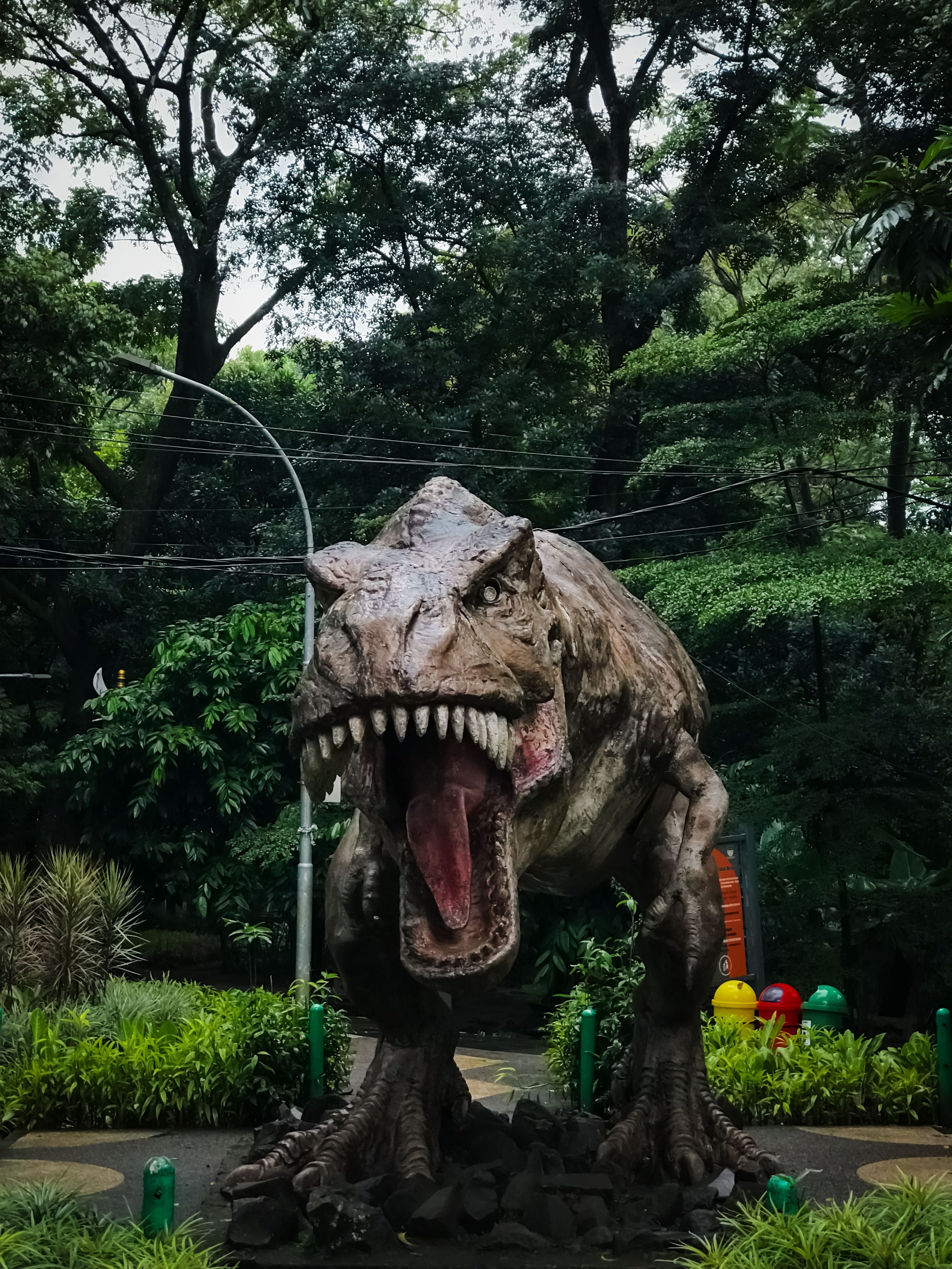 a trex statue in a public park
