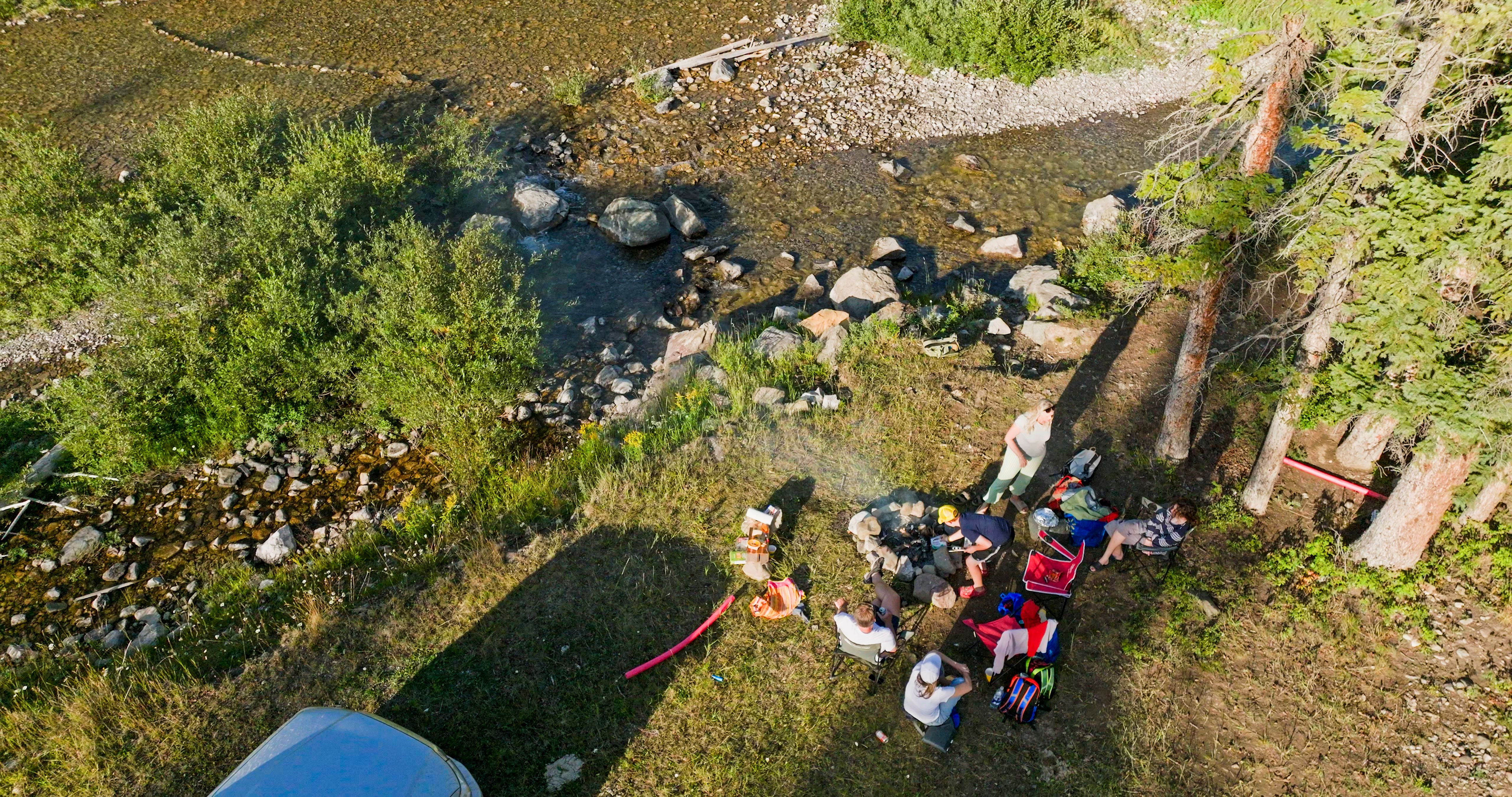 Aerial view of family enjoying mountain picnic beside stream