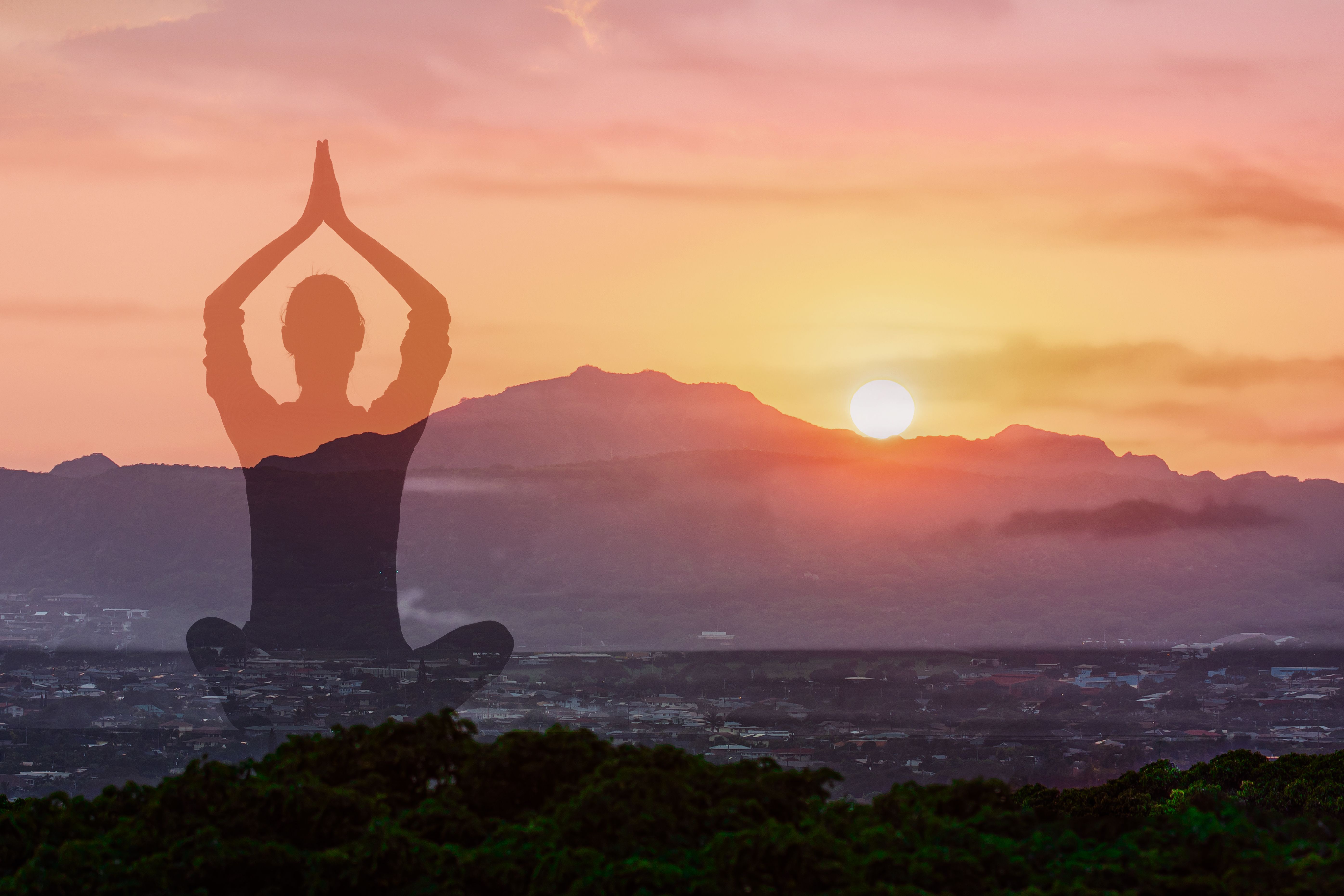 Woman practicing meditation at sunset.