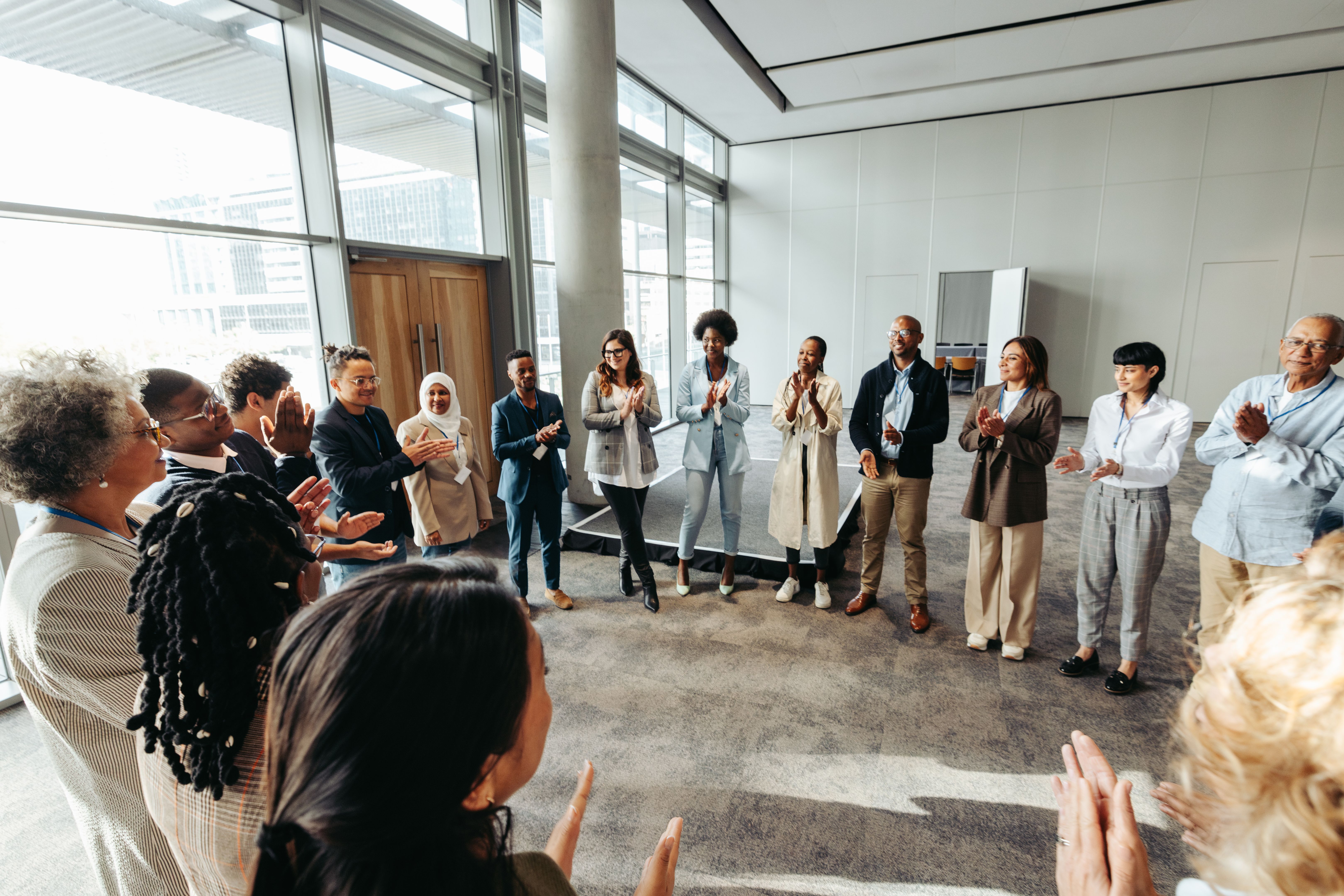 Équipe diversifiée en cercle participant à un exercice de teambuilding dans un espace de bureau moderne