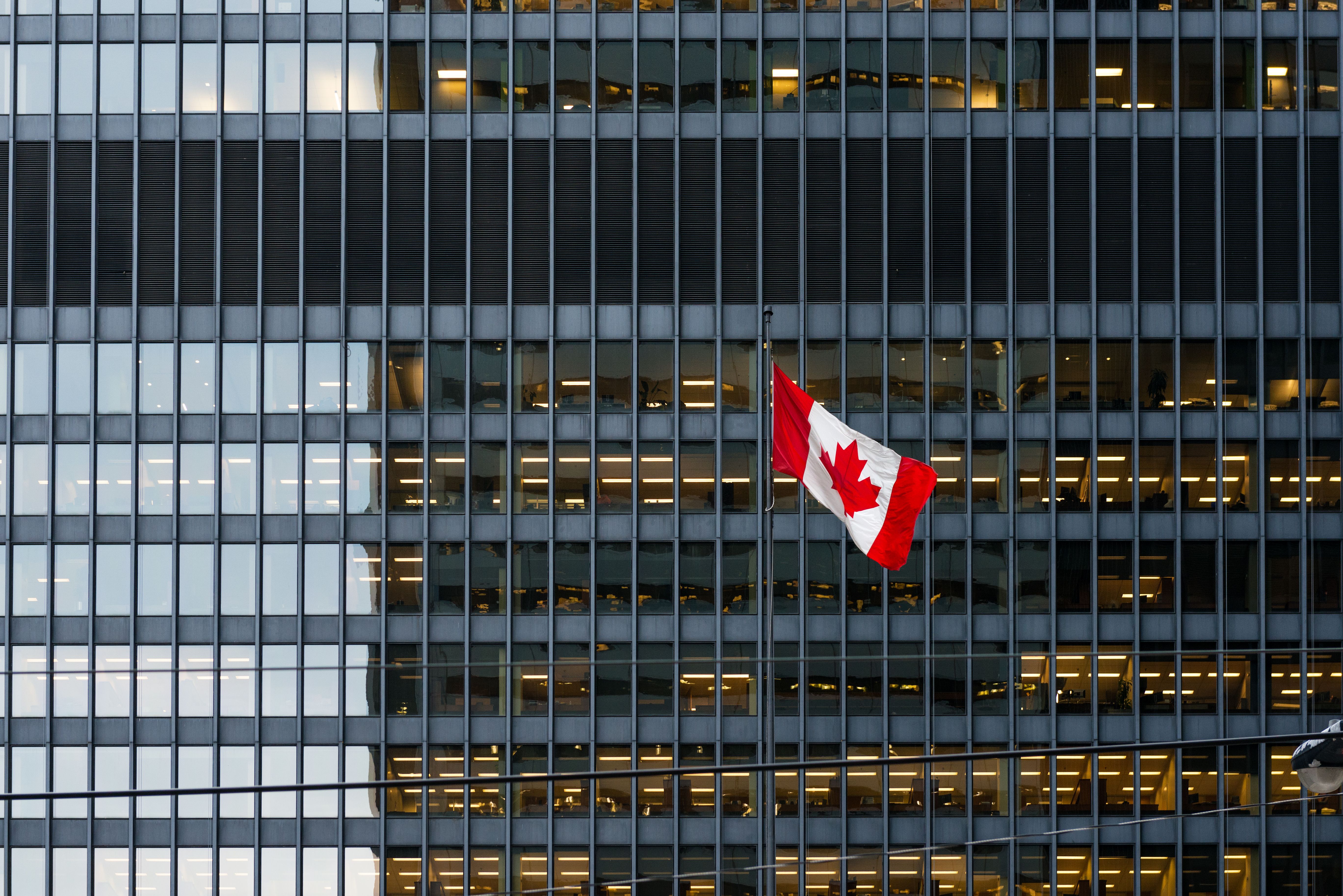 Canadian flag and modern office building in downtown Toronto