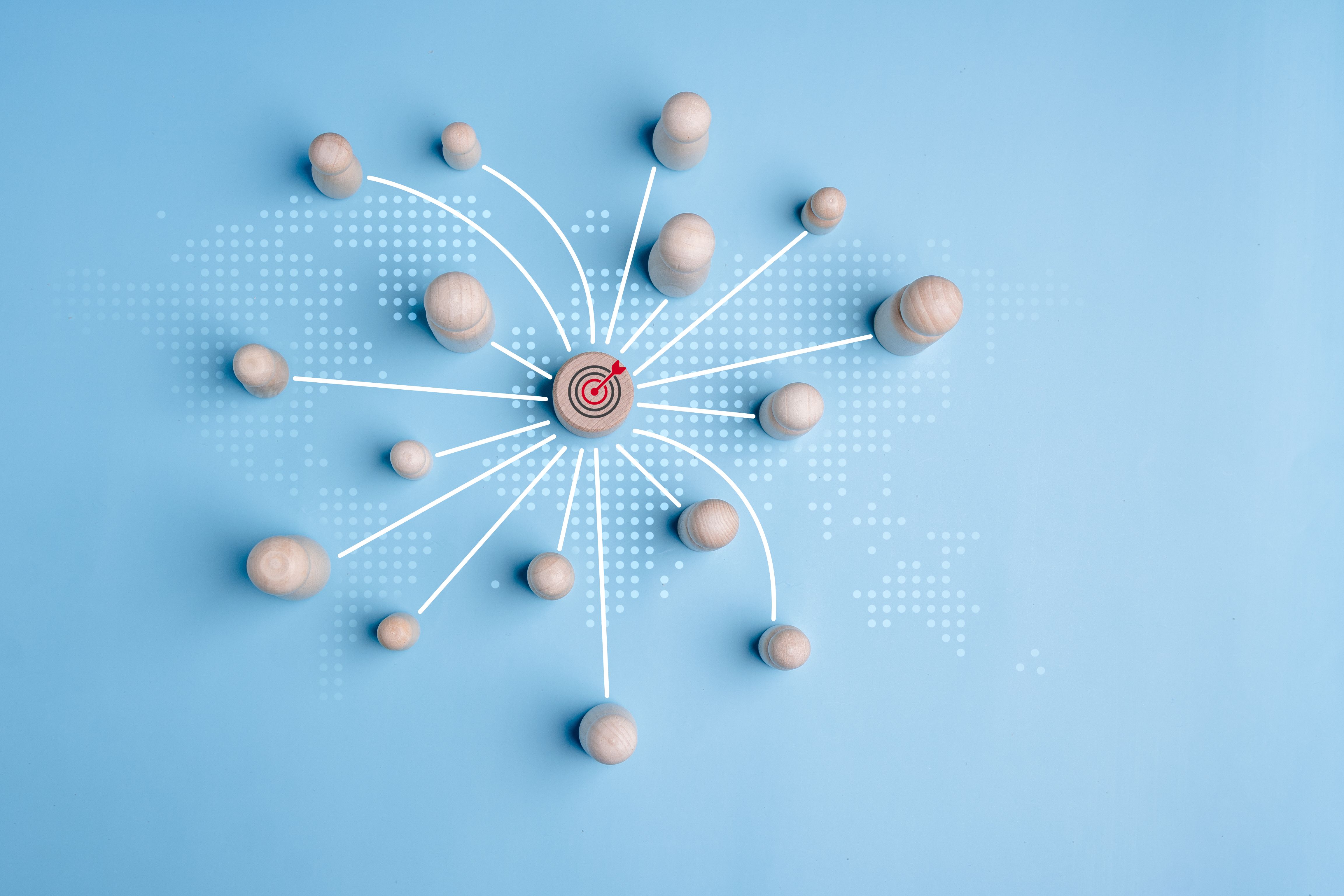 Wooden block with target icon linked with wooden peg dolls connect link for customers focus group, development resource achievement to target, customer relationship management concept