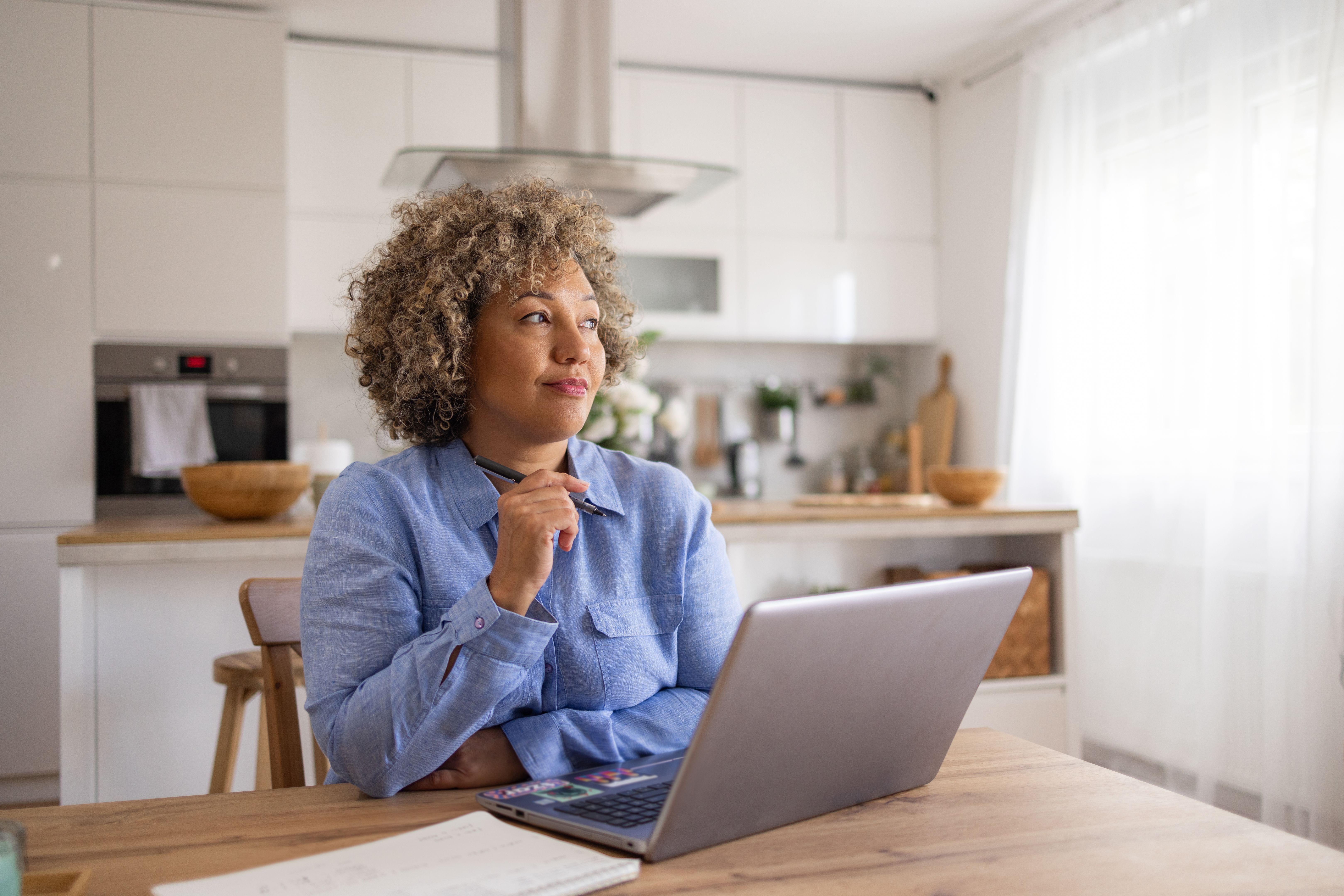 Pensive businesswoman working on laptop at home office.